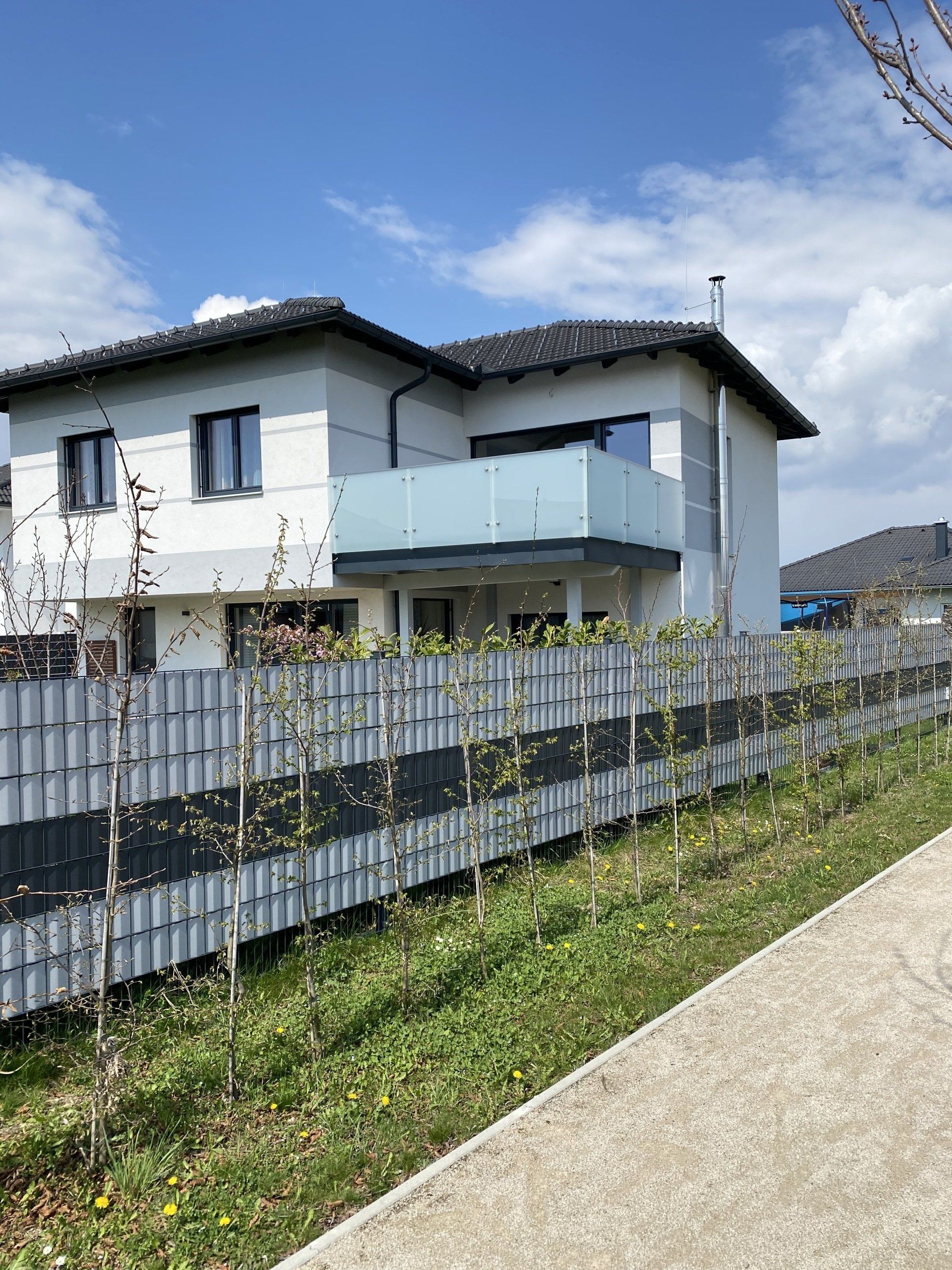 Ein Haus mit einem Balkon und einem Zaun darum