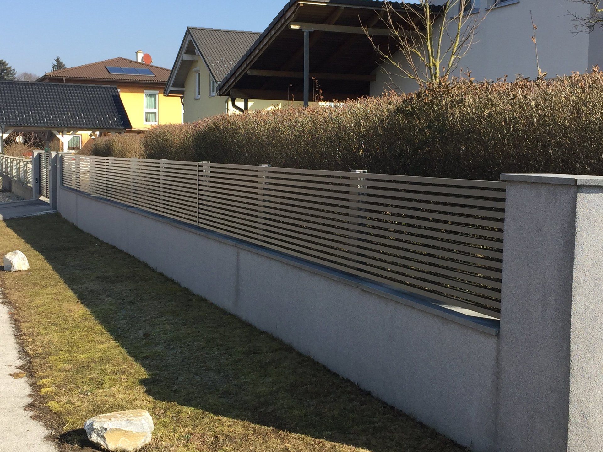 Ein Zaun mit einem gelben Haus im Hintergrund