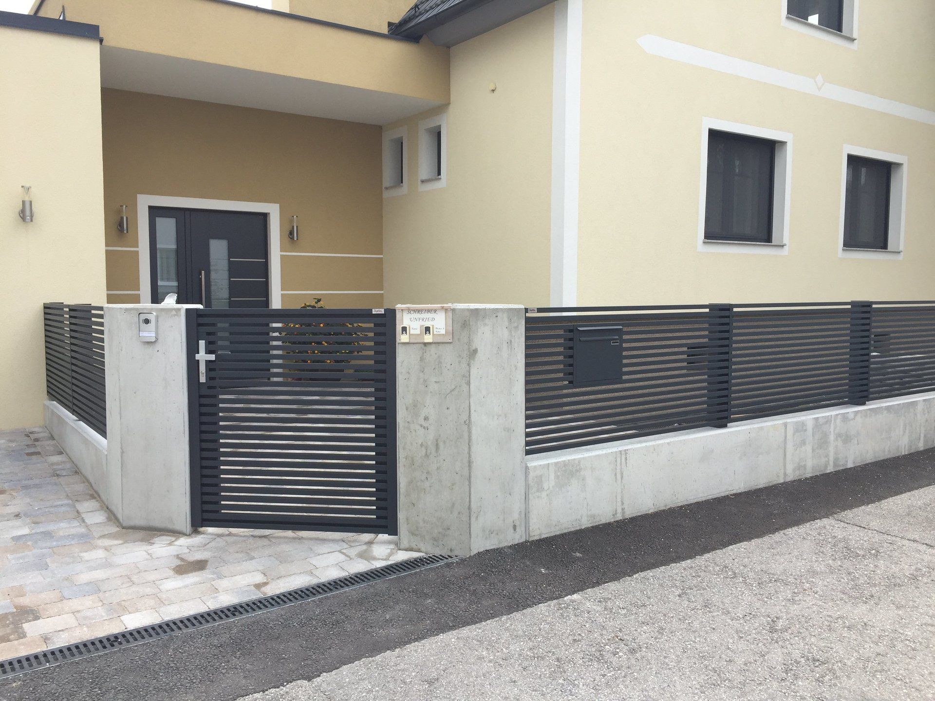 Ein Haus mit einem Zaun und einem Briefkasten davor