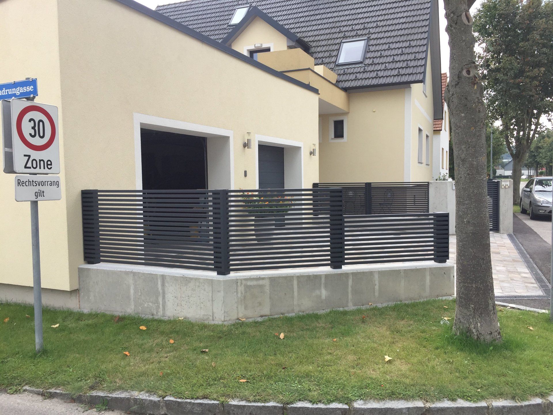 Ein gelbes Haus mit einem Schild mit der Aufschrift „Zone 30“