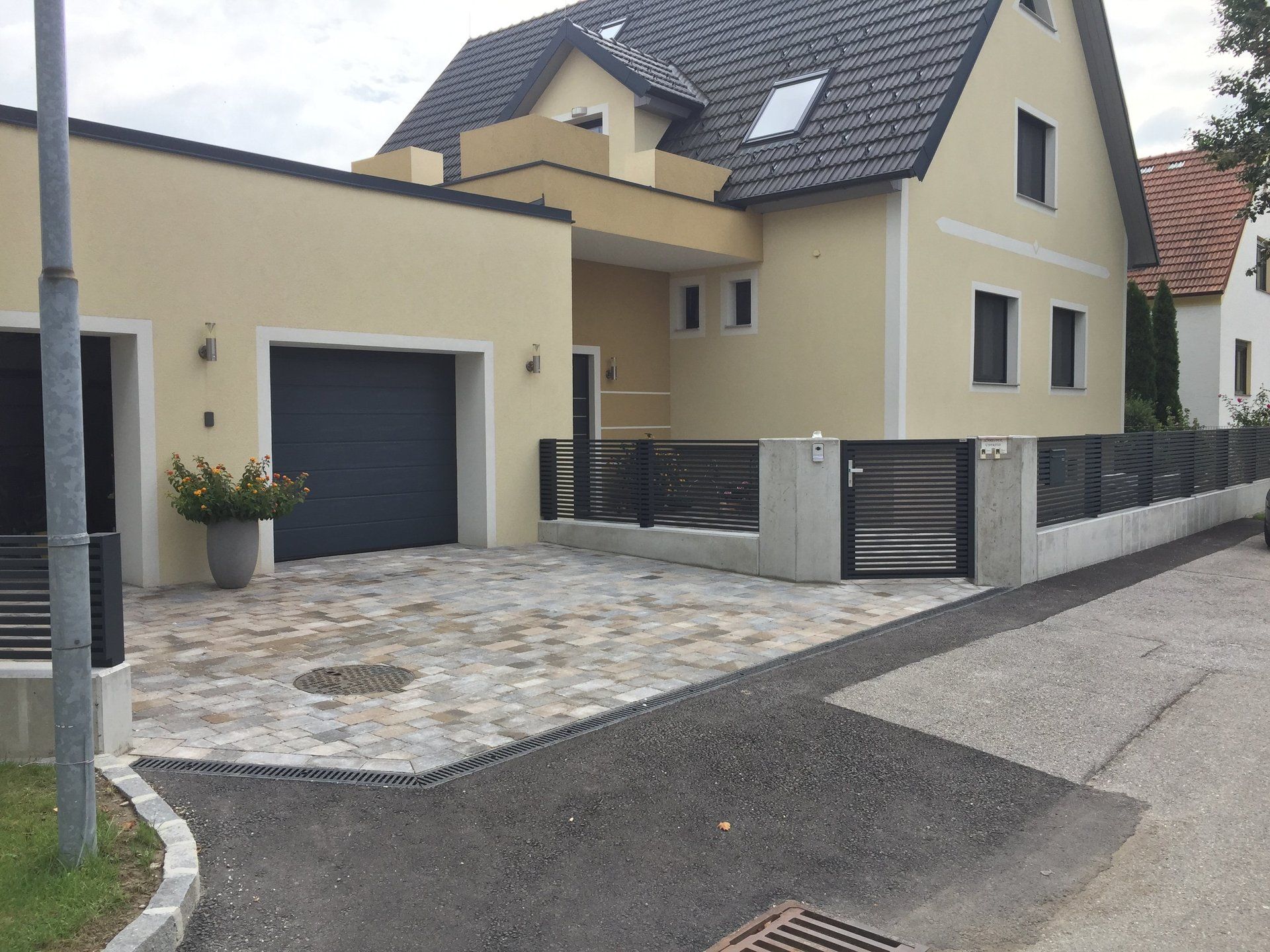 Ein großes gelbes Haus mit einem schwarzen Garagentor