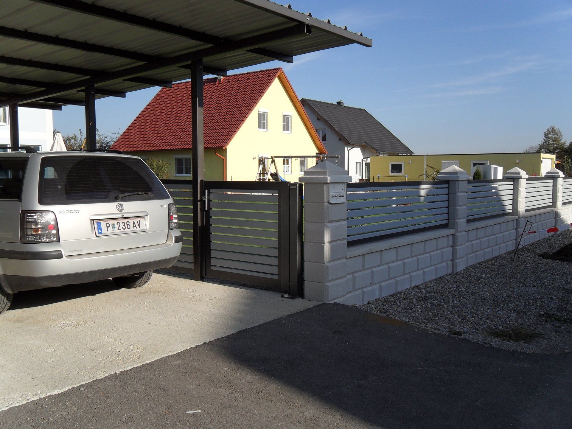 Ein Auto ist unter einem Vordach geparkt und hat ein Nummernschild mit der Aufschrift „btp“.