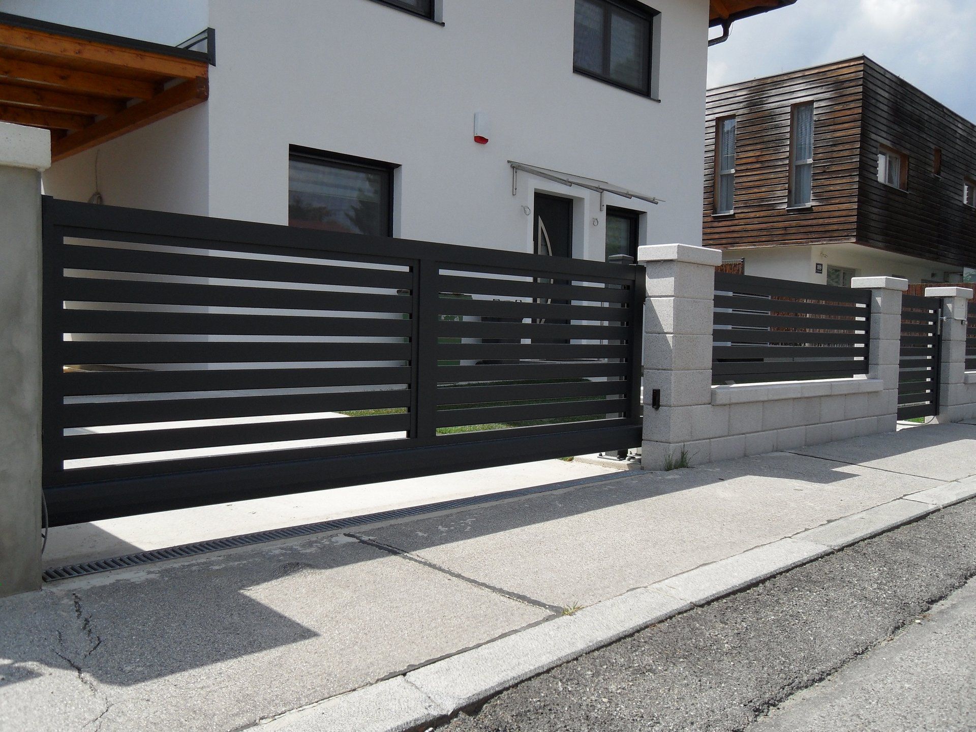 Ein weißes Haus mit einem schwarzen Zaun davor