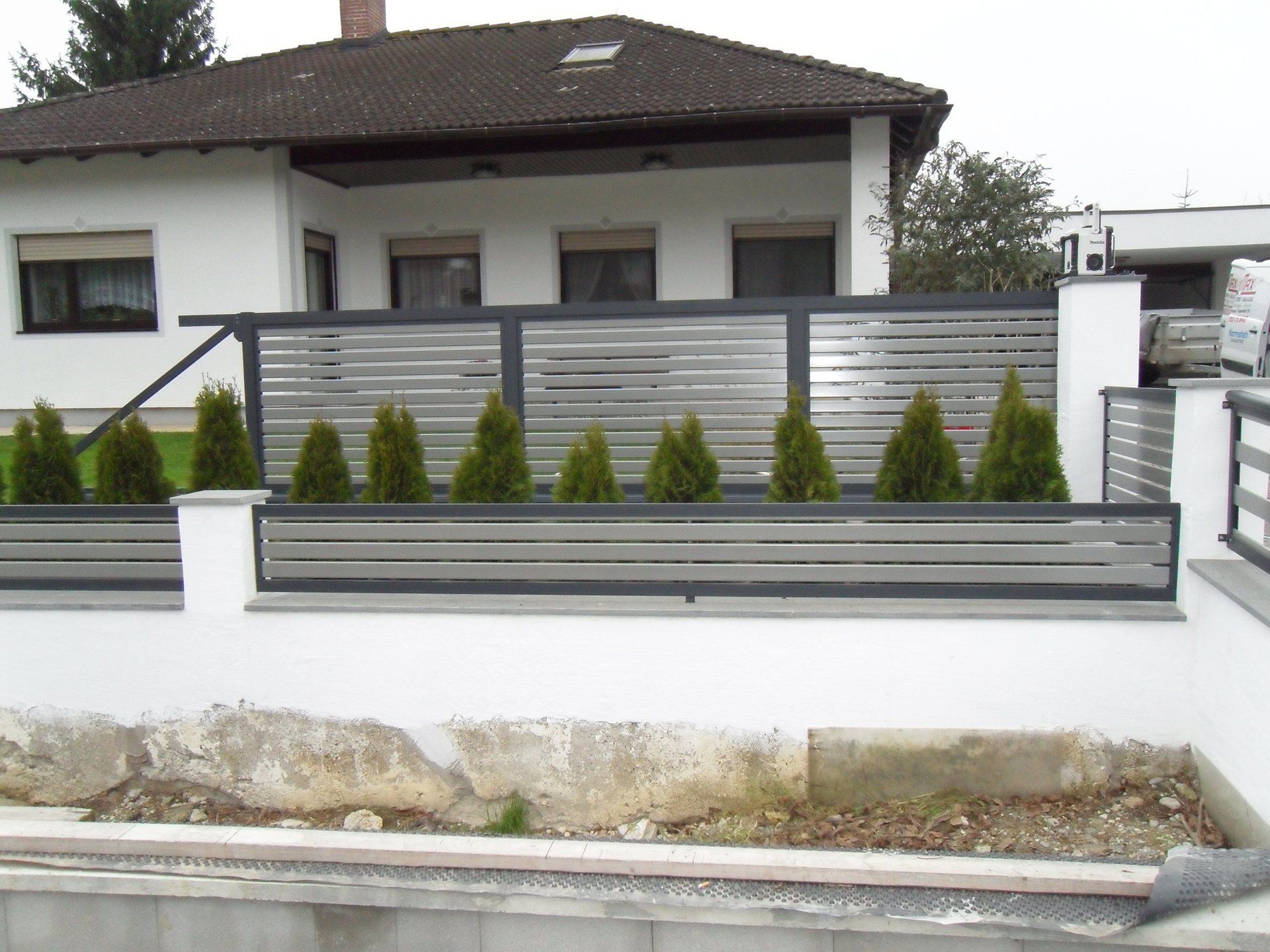 Ein weißes Haus mit einem Zaun darum