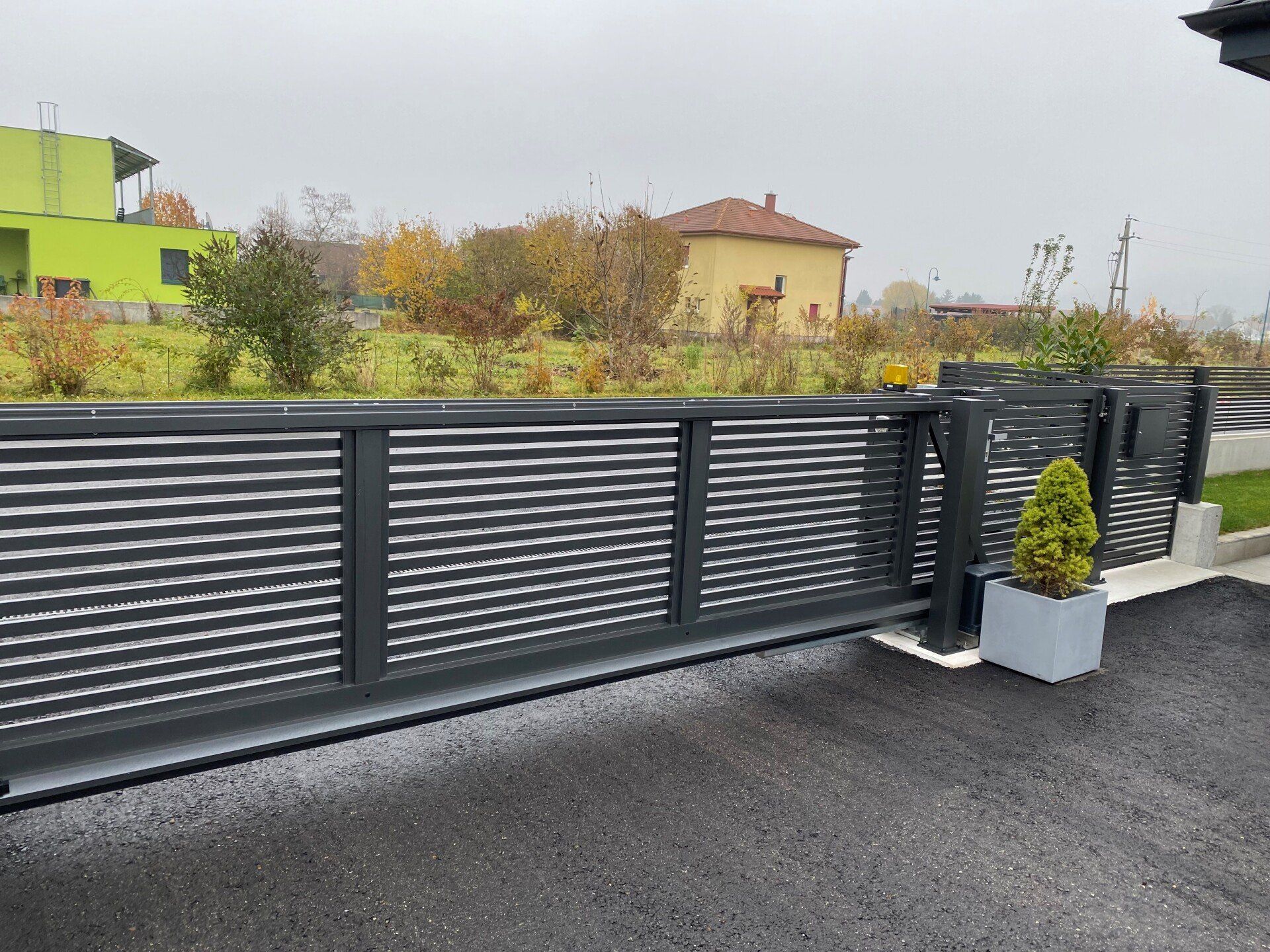 Ein Schiebetor mit einer Topfpflanze davor.