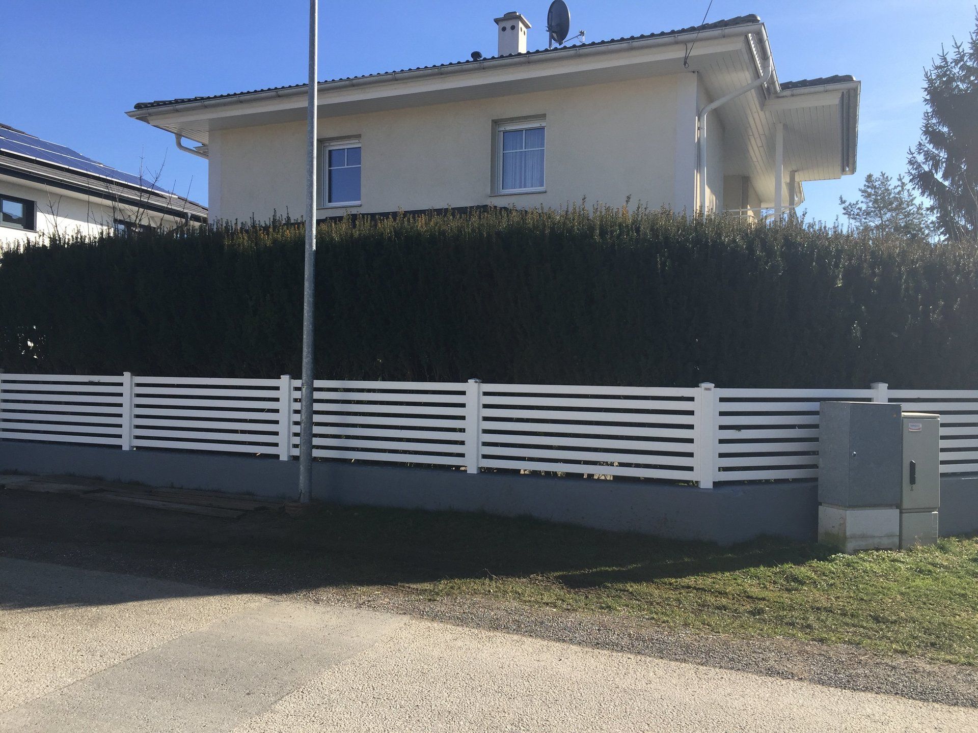 Ein weißes Haus mit einem weißen Zaun davor