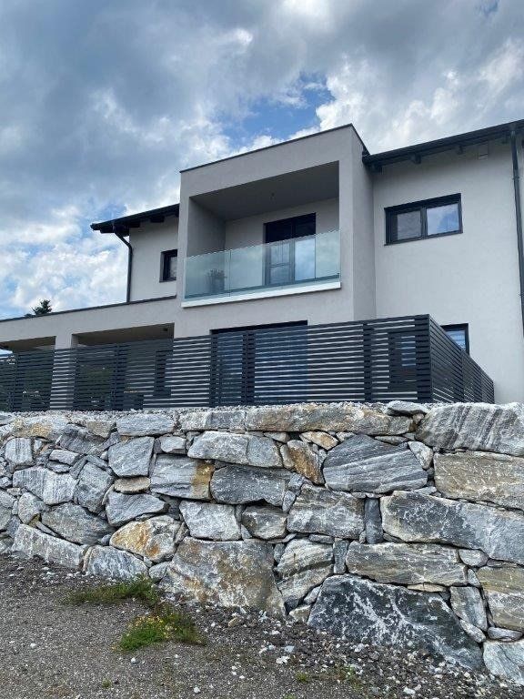 Ein großes Haus mit einer Steinmauer davor