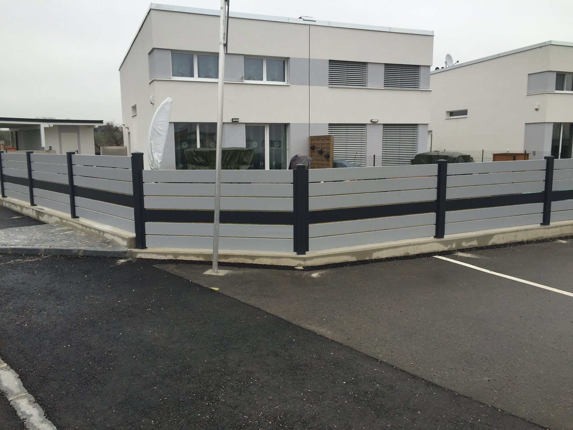 Ein weißes Haus mit einem schwarzen Zaun davor