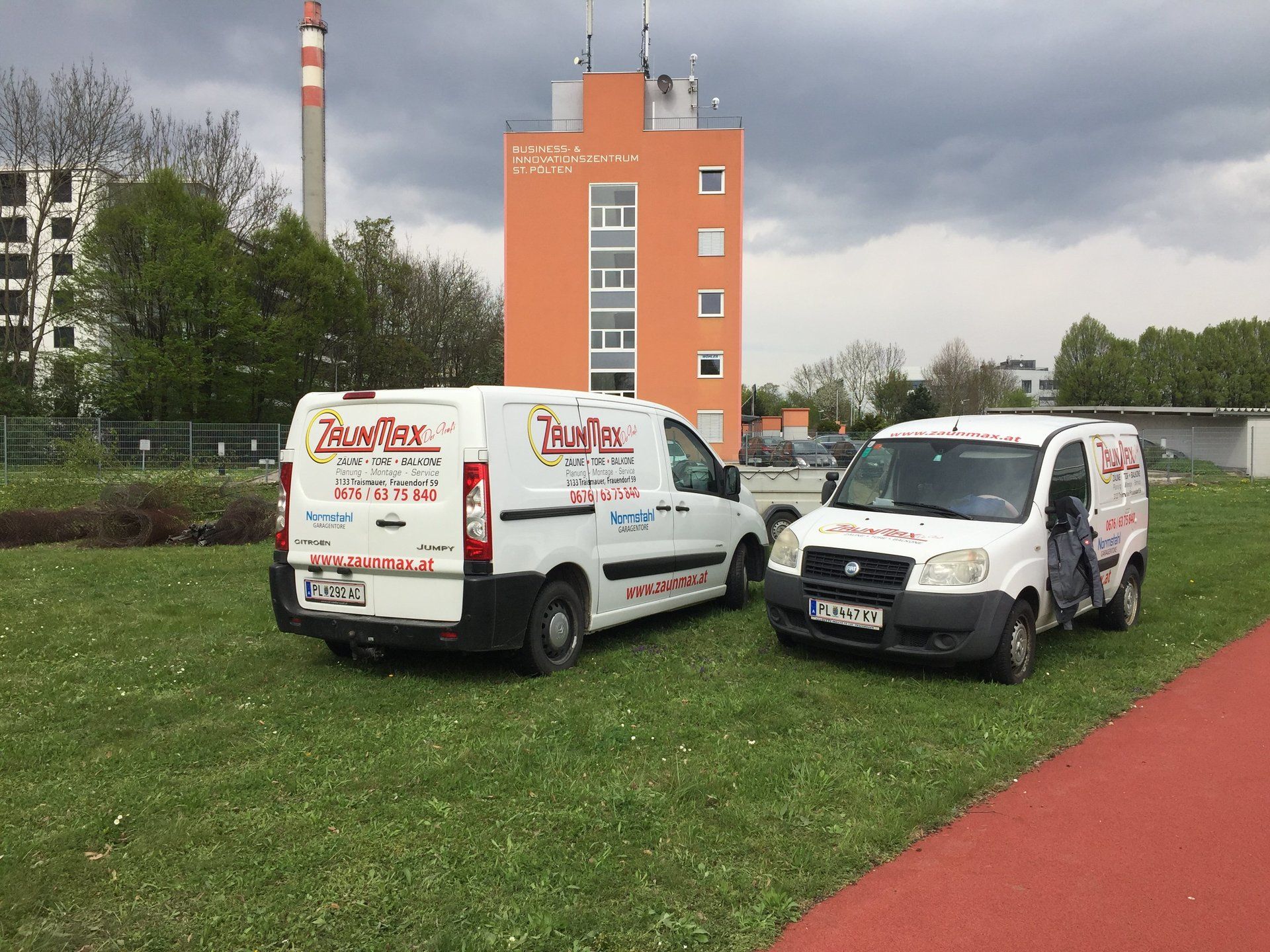 Zwei weiße Lieferwagen stehen nebeneinander auf einer Wiese.