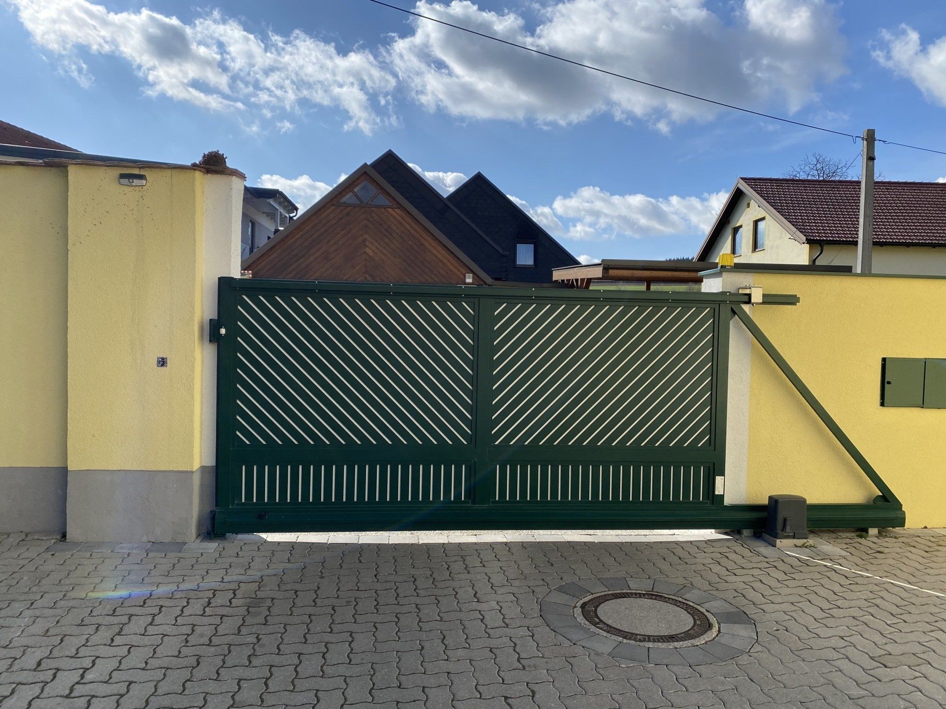 Ein grünes Schiebetor vor einer gelben Wand