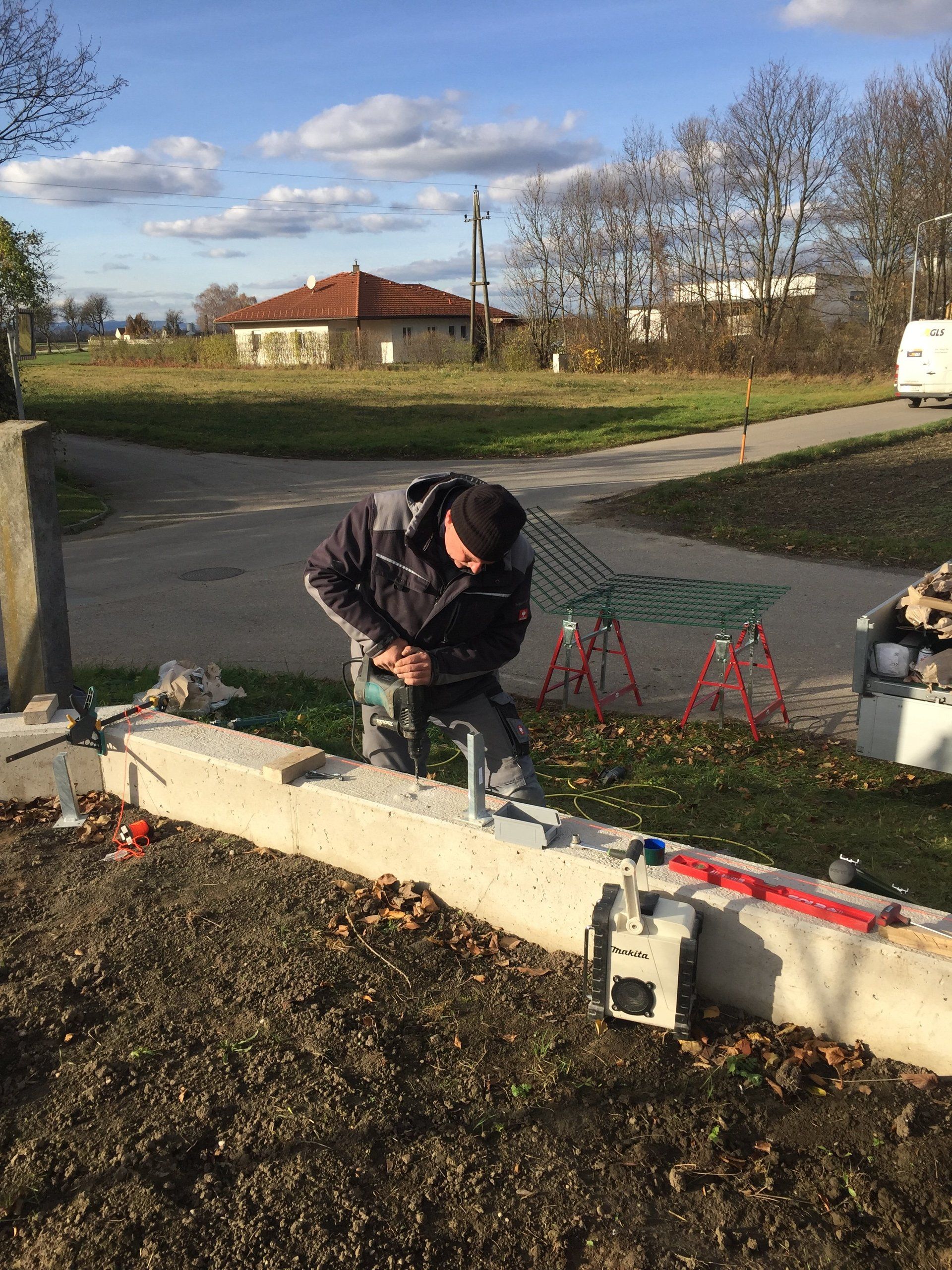 Ein Mann arbeitet mit einer Bohrmaschine an einer Betonwand.