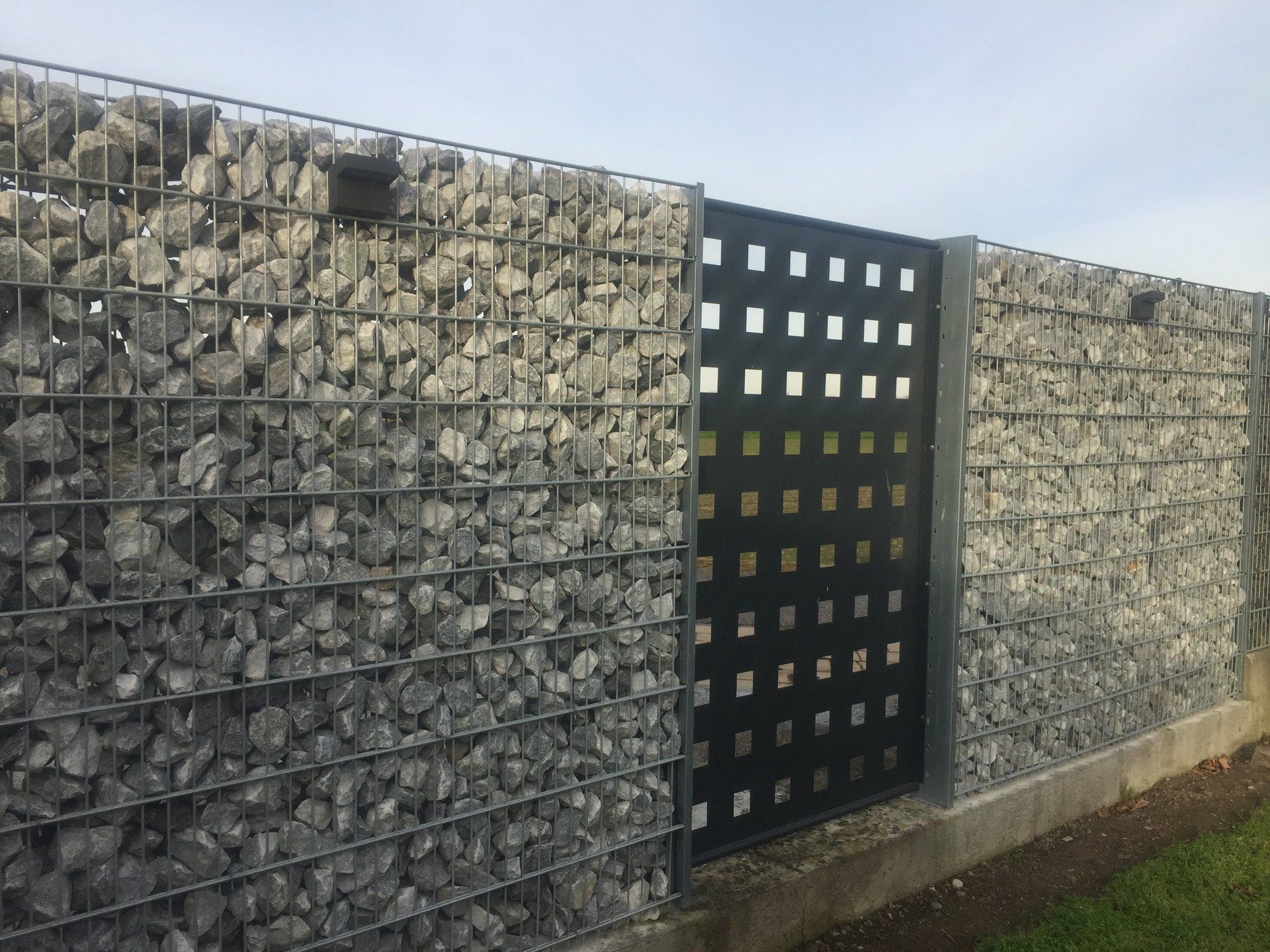 Ein Zaun aus Steinen und ein Metalltor