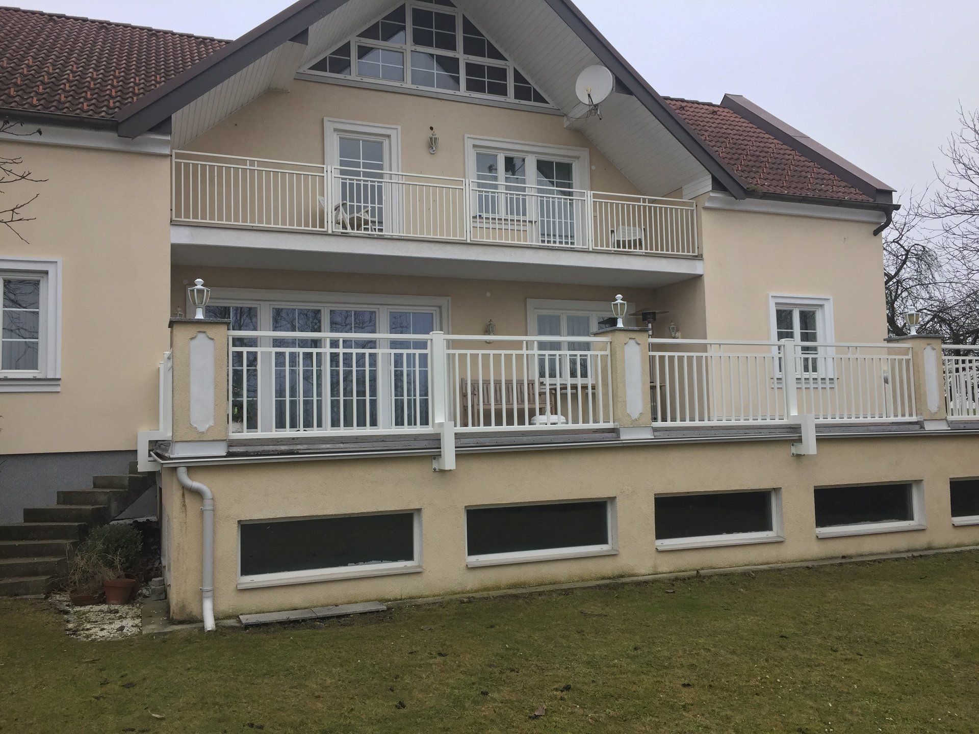 Ein großes Haus mit Balkon und Satellitenschüssel auf dem Dach