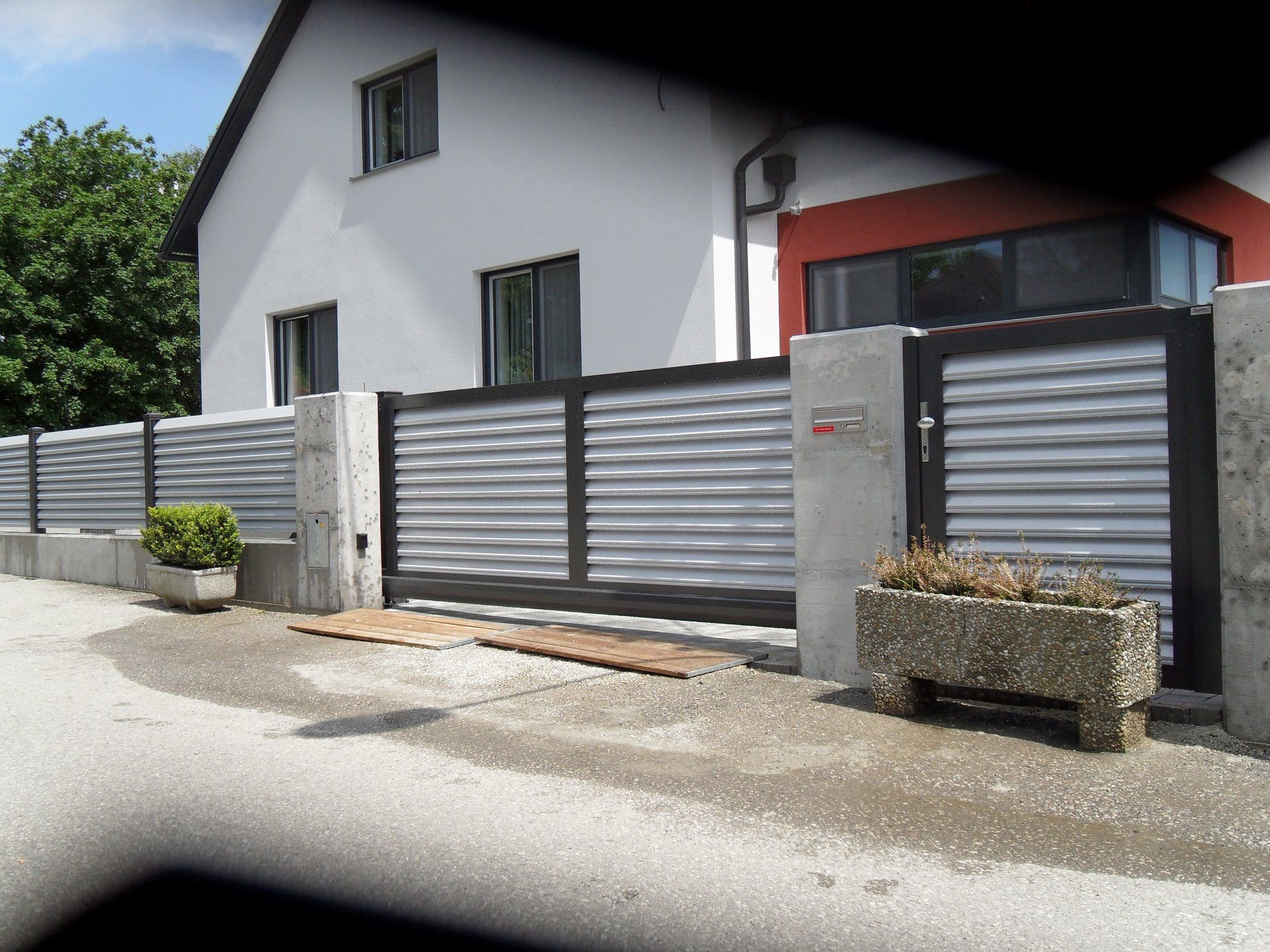 Ein Haus mit einem Zaun und einem Briefkasten davor