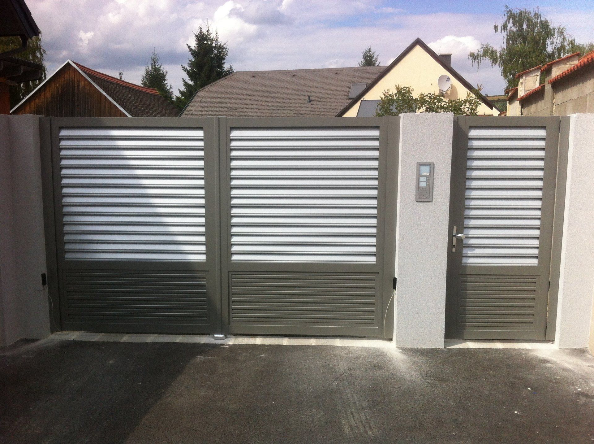 Ein Zaun mit Fensterläden und ein Haus im Hintergrund