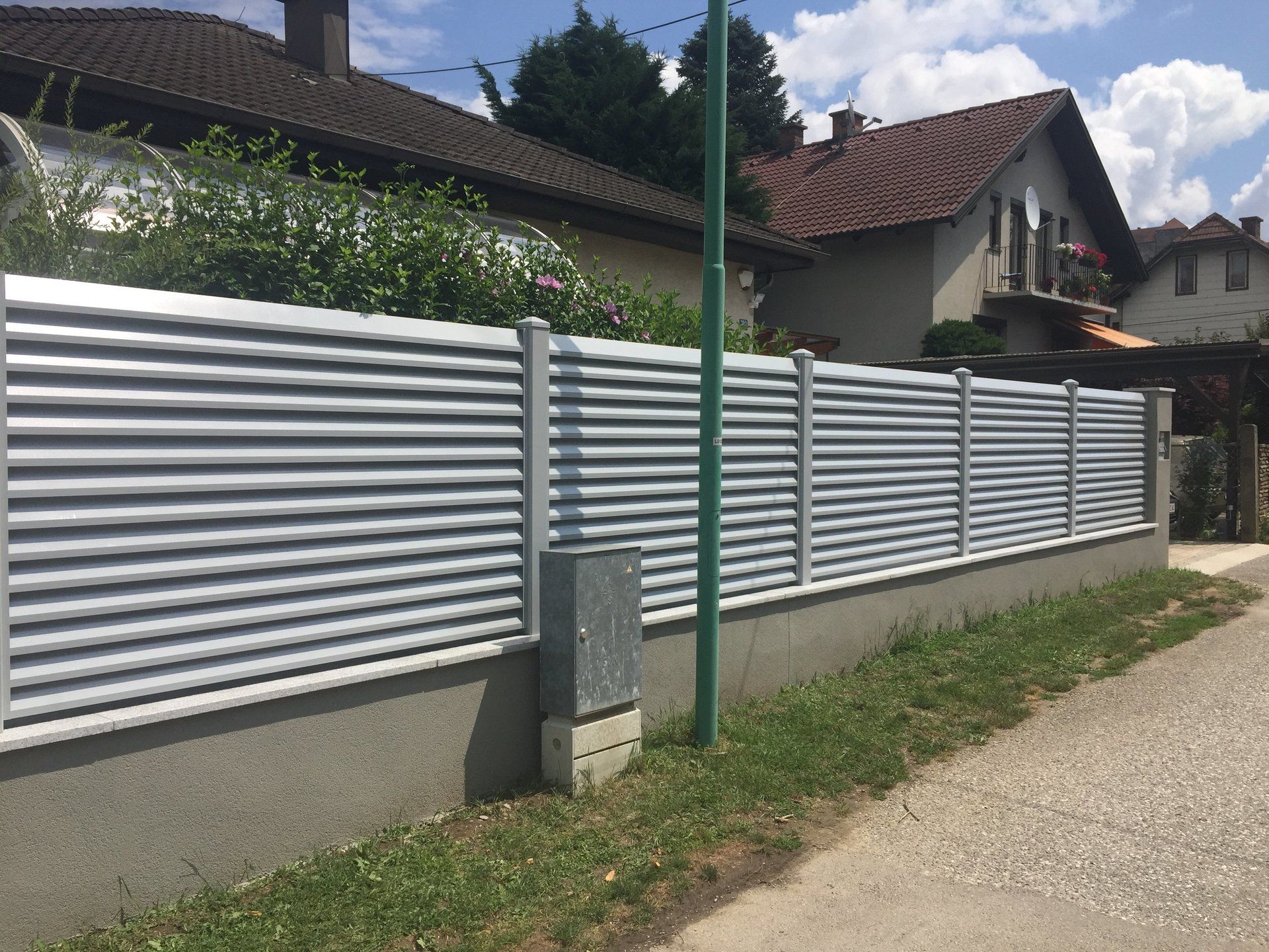 Ein weißer Zaun steht am Straßenrand