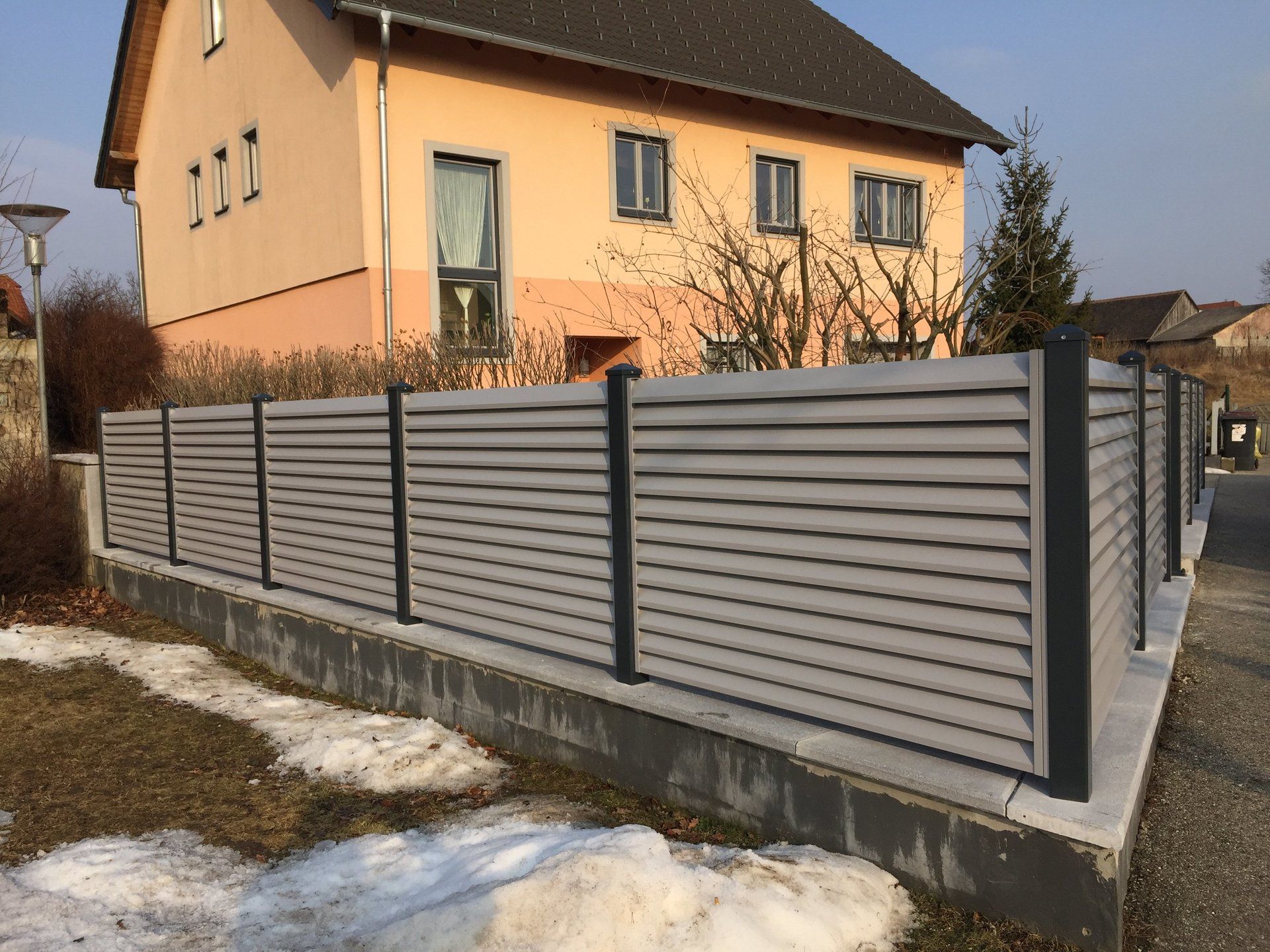 Ein großes Haus mit einem Zaun davor