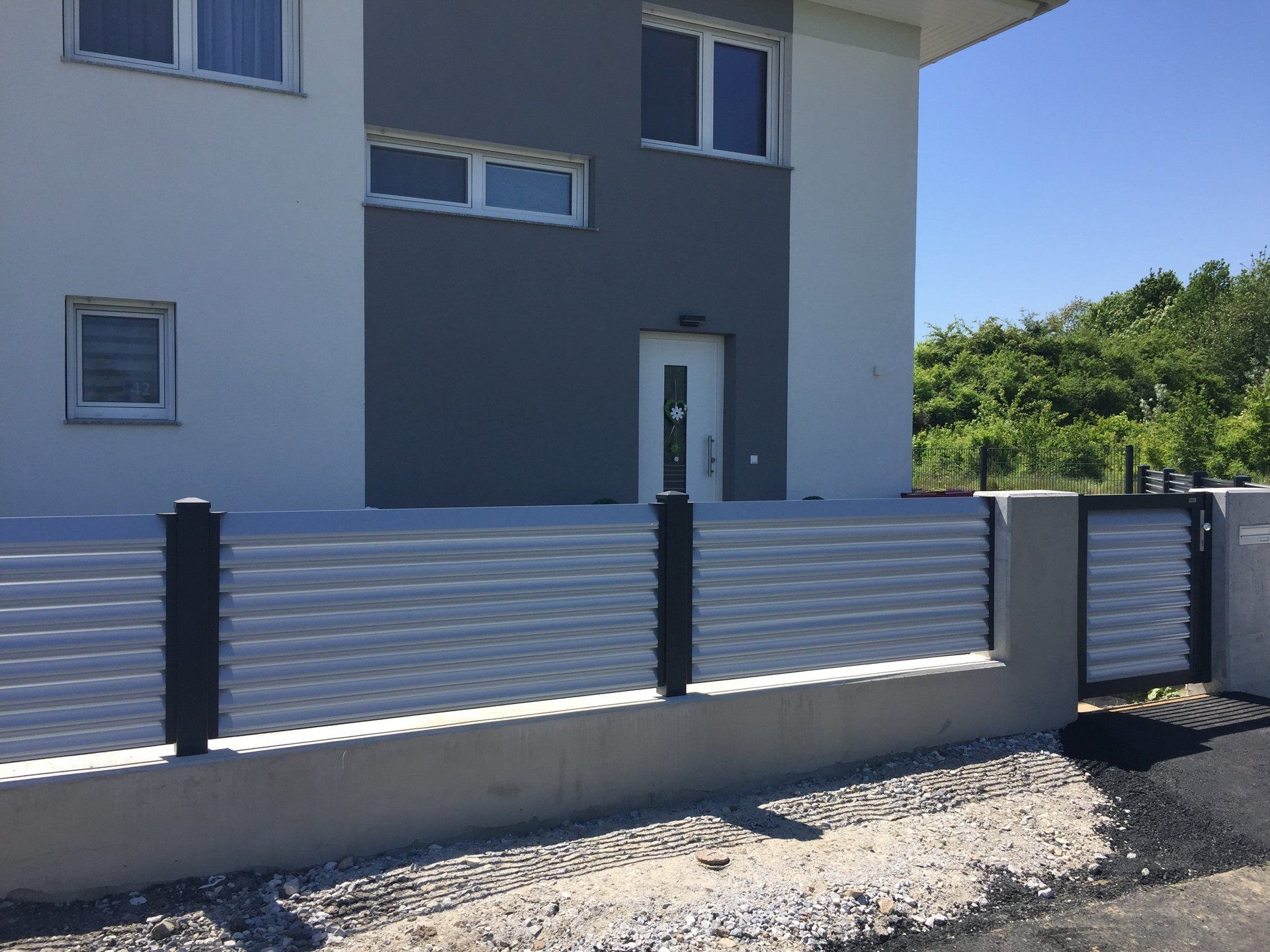 Ein weißes Haus mit einem Zaun davor