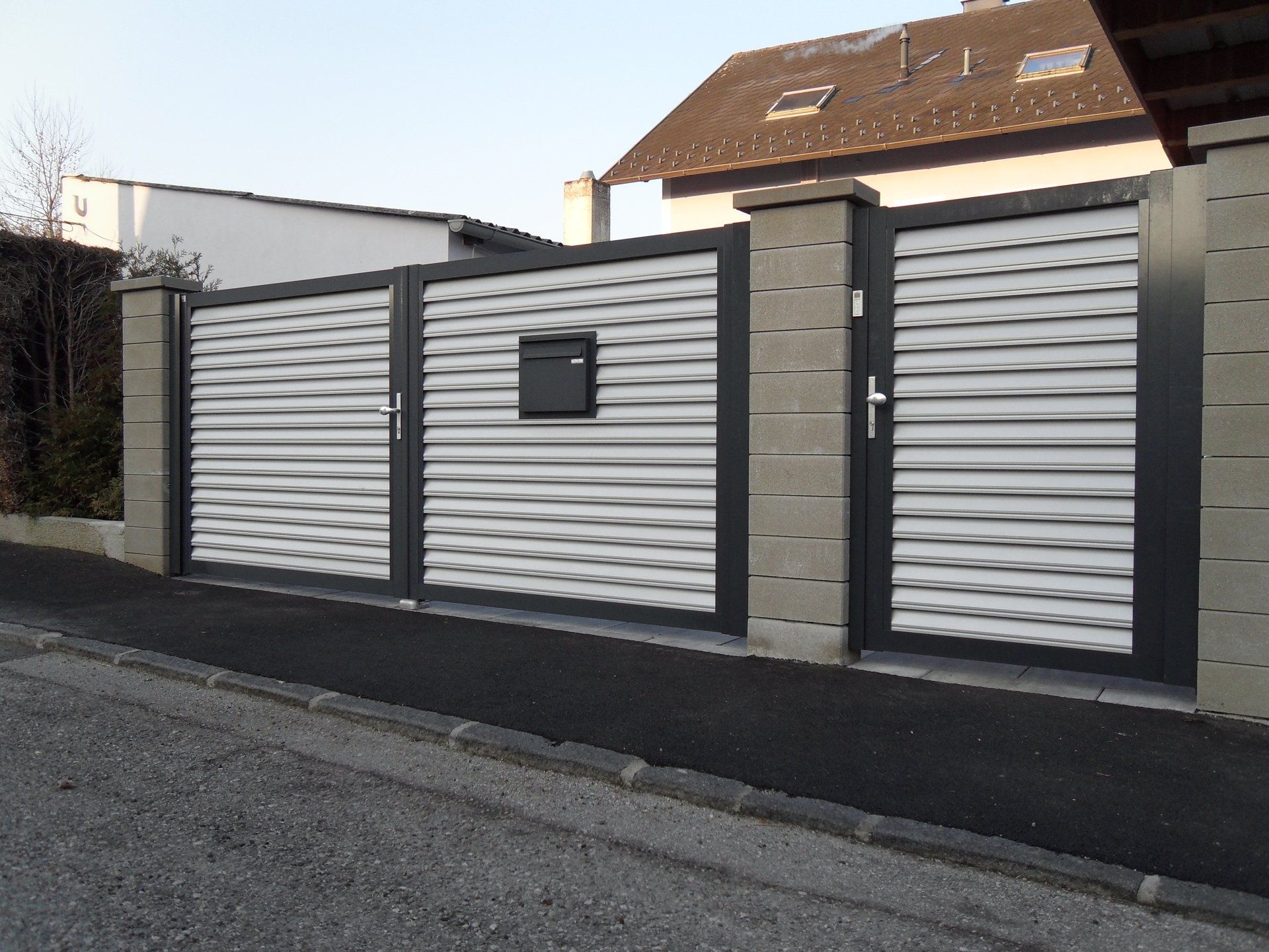 Ein Zaun mit einem Briefkasten in der Mitte