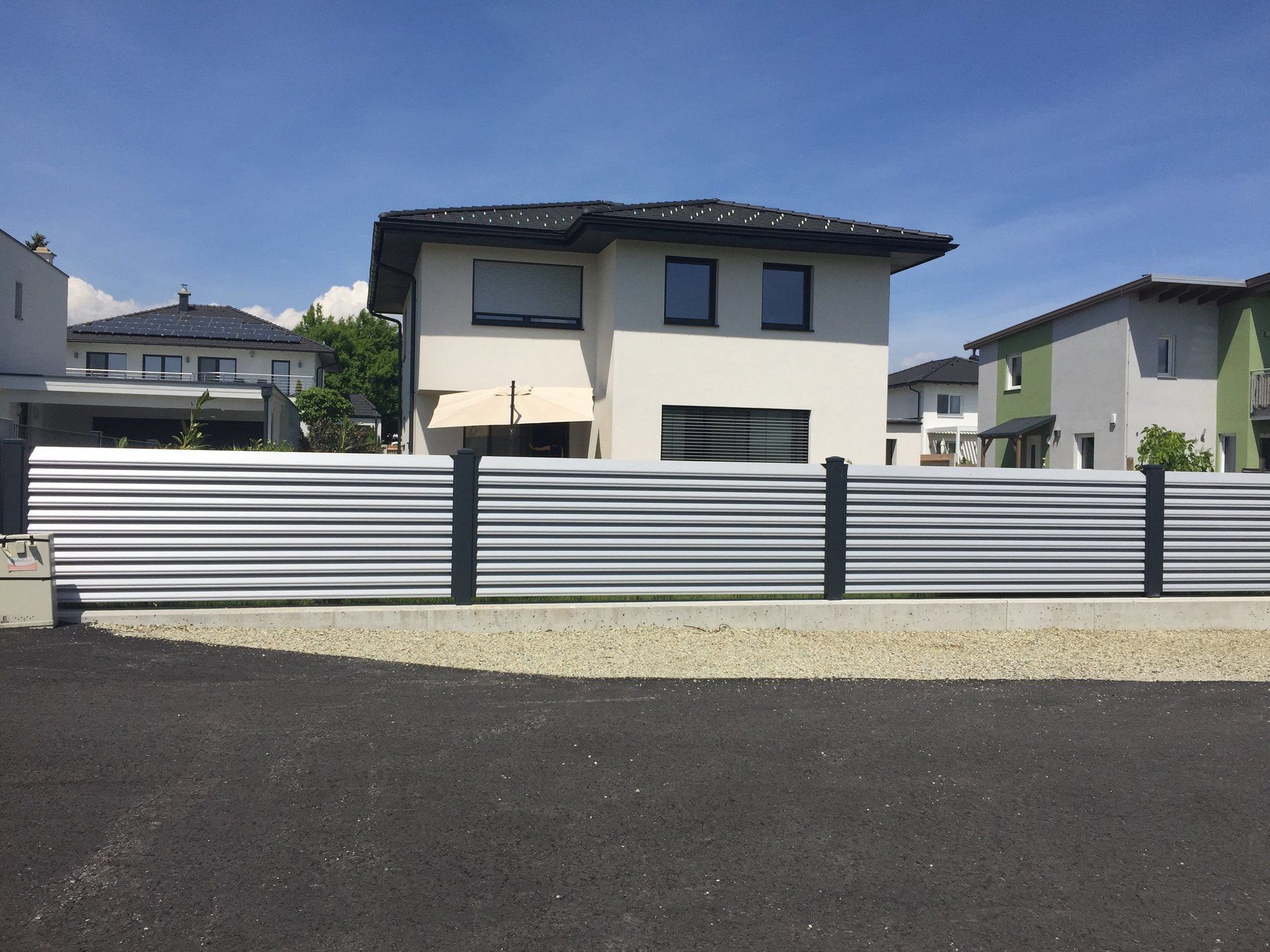 Ein Haus mit einem Metallzaun davor