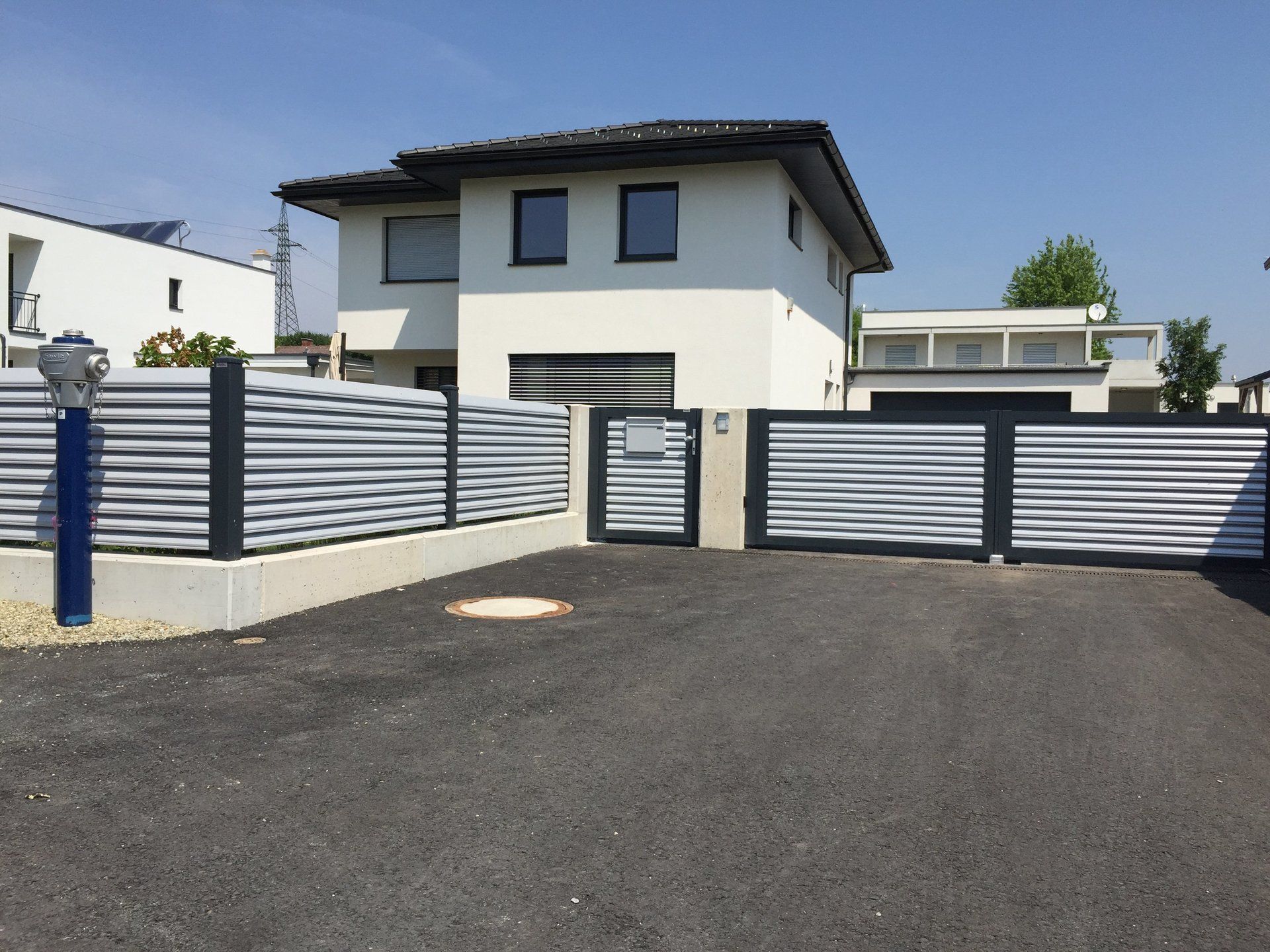 Ein Haus mit einem Zaun und einem Tor davor