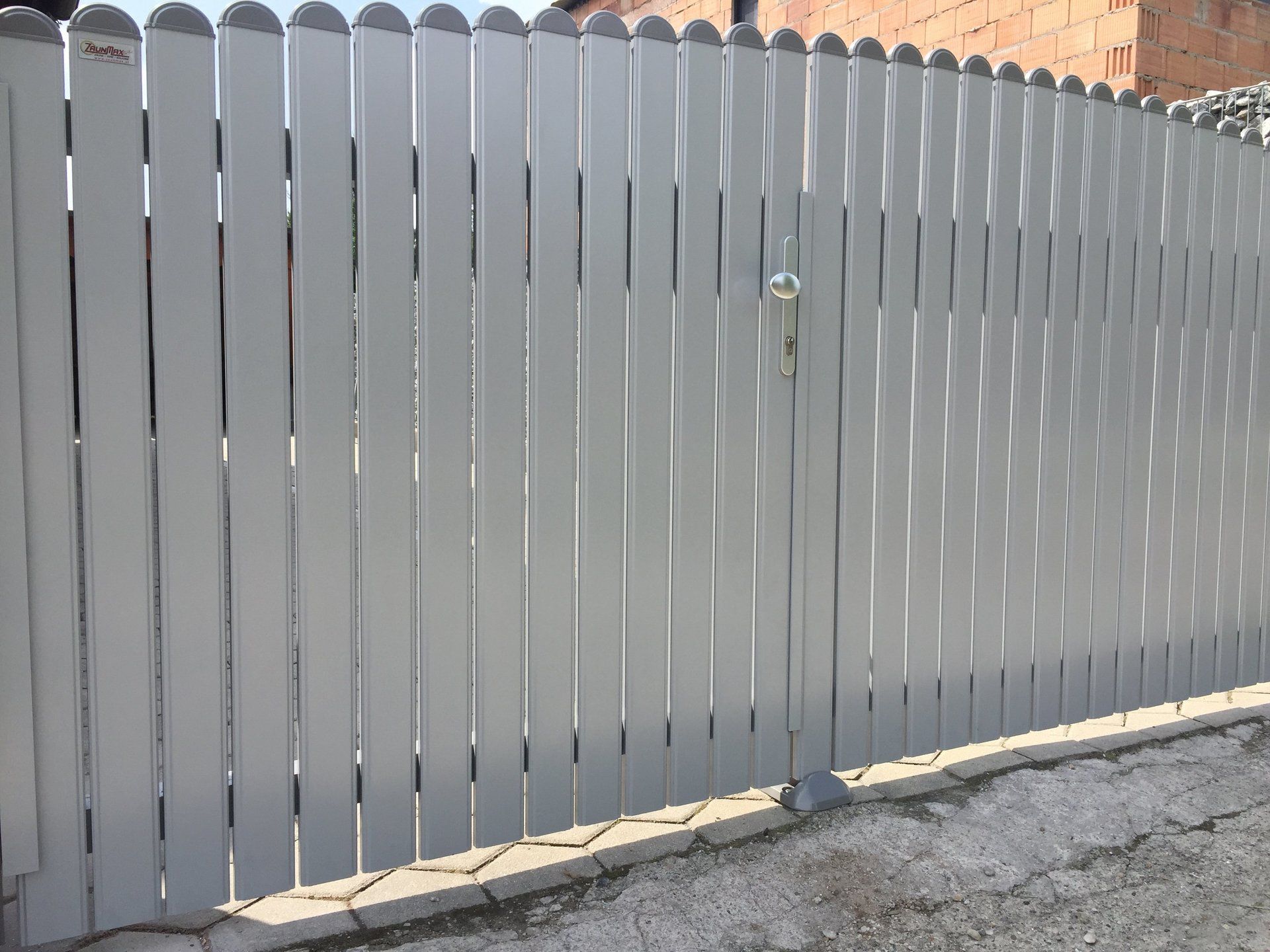 Ein weißer Holzzaun mit einem Tor in der Mitte.