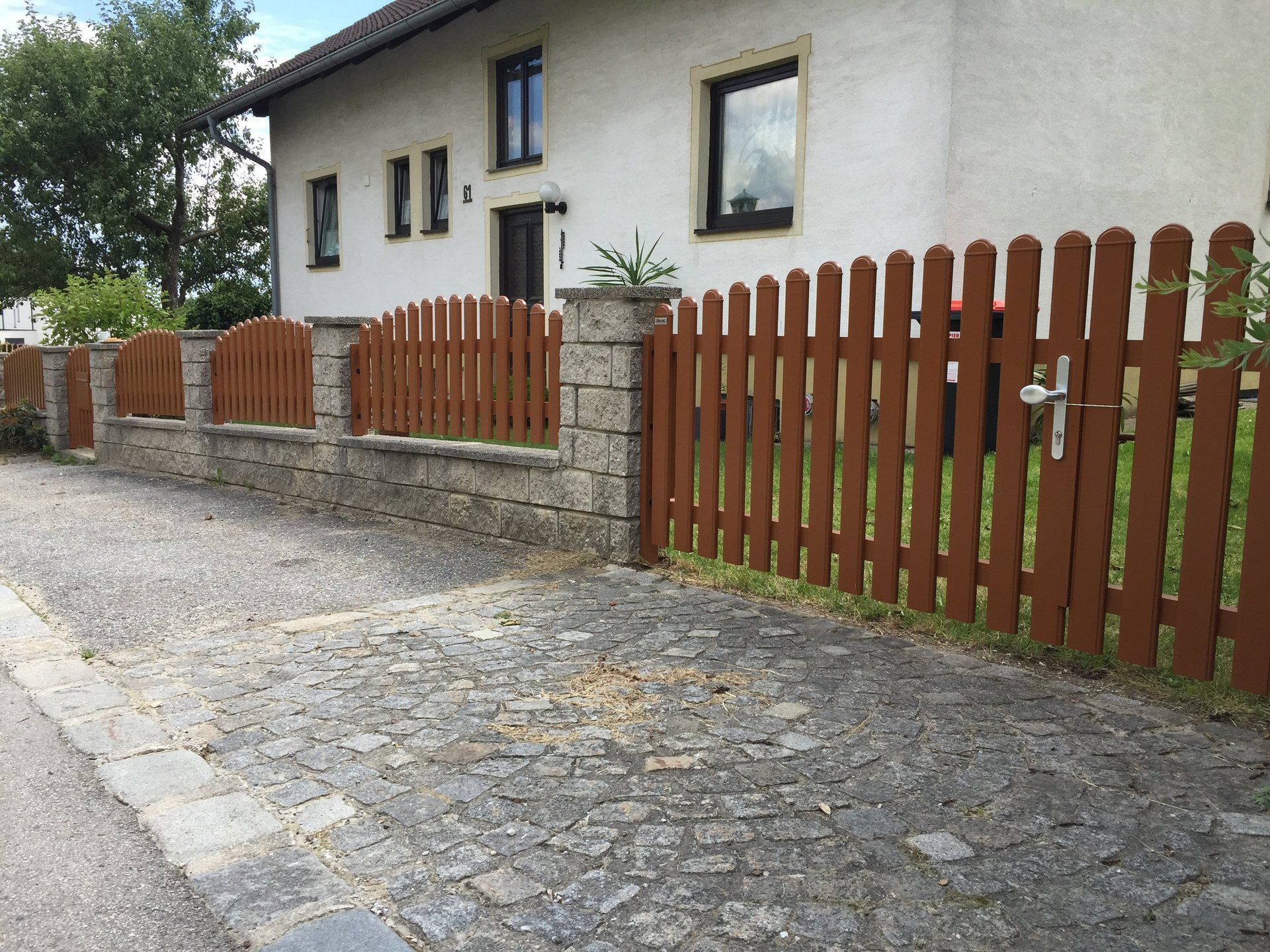 Ein weißes Haus mit einem Holzzaun davor