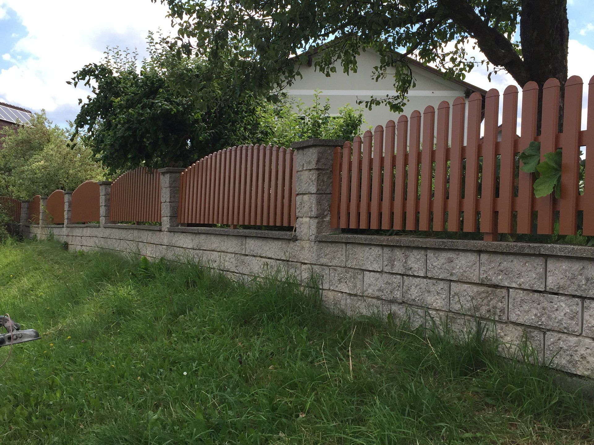 Eine Backsteinmauer mit einem Holzzaun darum herum