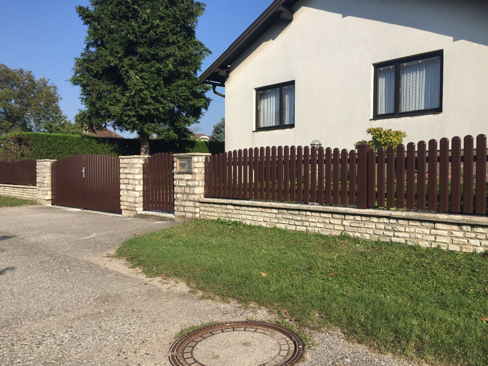 Ein weißes Haus mit einem Holzzaun darum