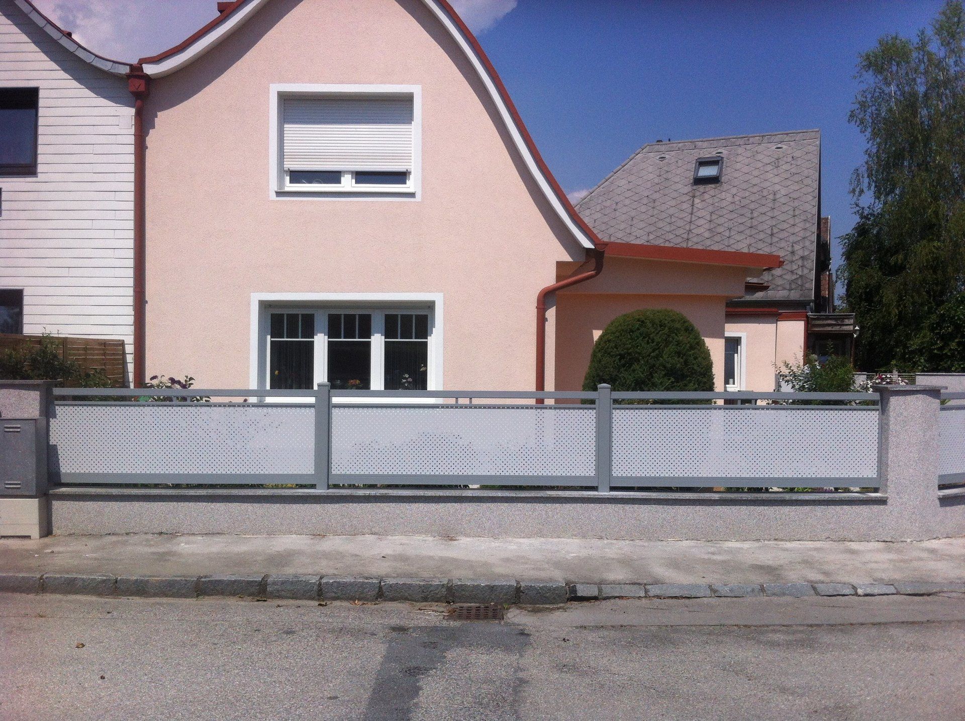 Ein Haus mit einem weißen Zaun davor