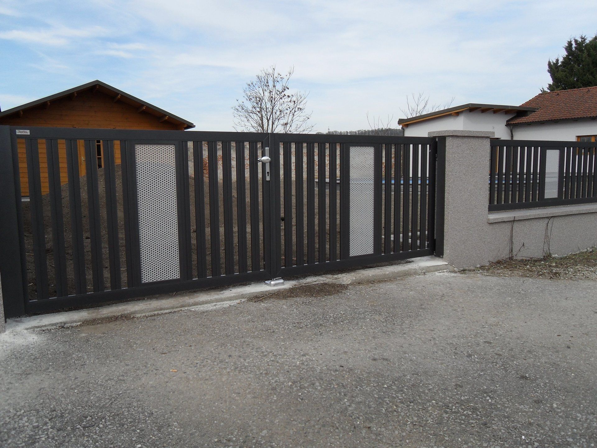 Ein Zaun mit Schiebetor vor einem Haus