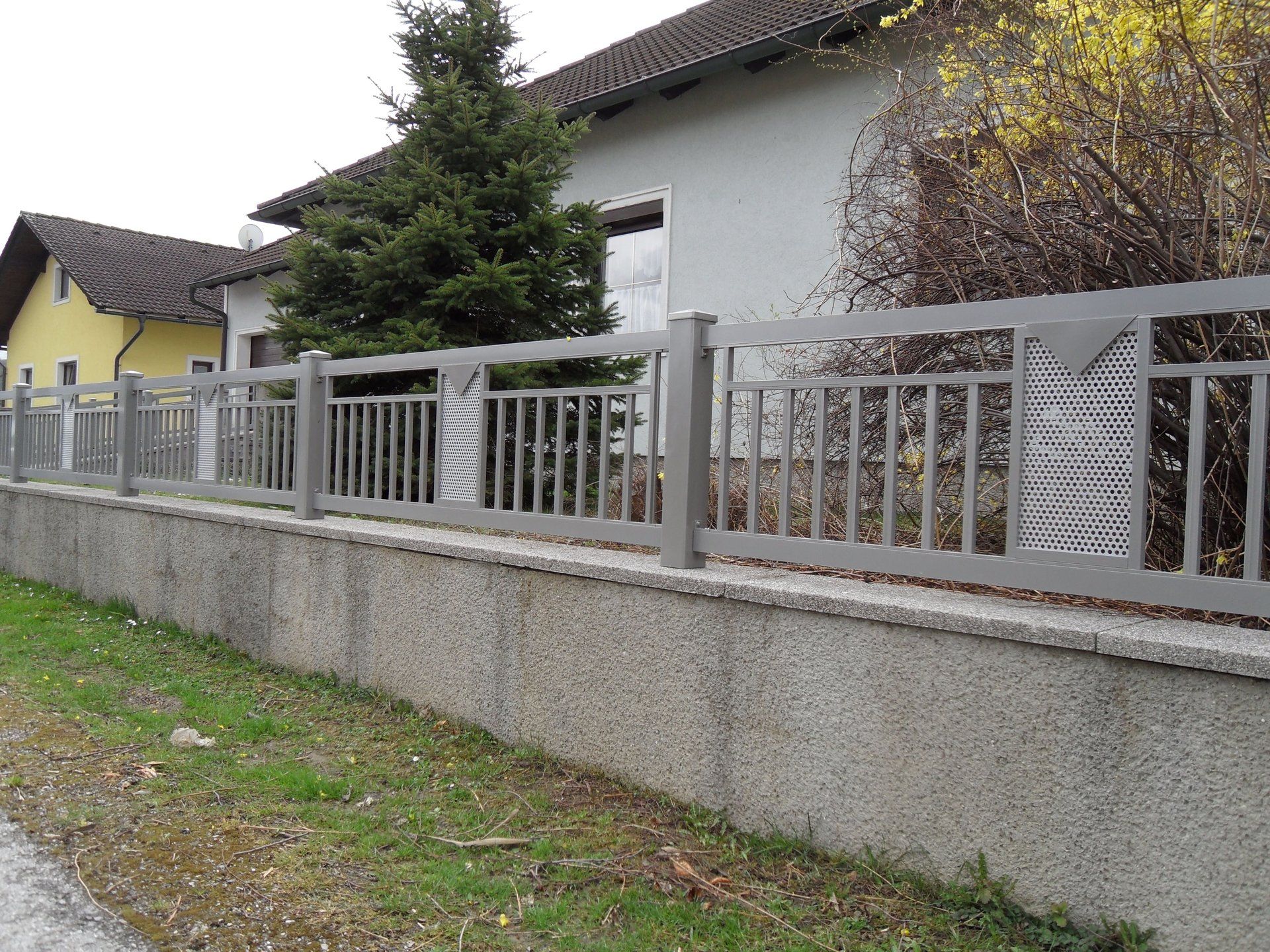 Ein Zaun mit einem gelben Haus im Hintergrund