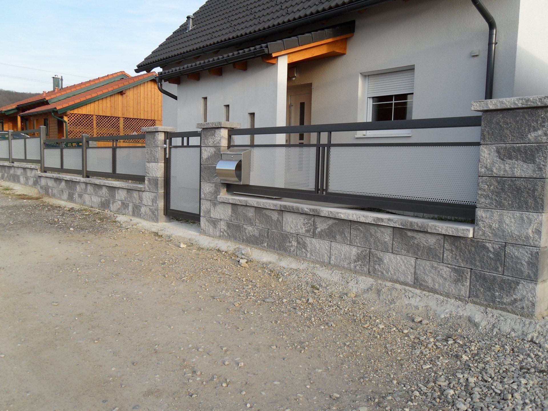 Ein Haus mit einem Zaun und einem Briefkasten davor