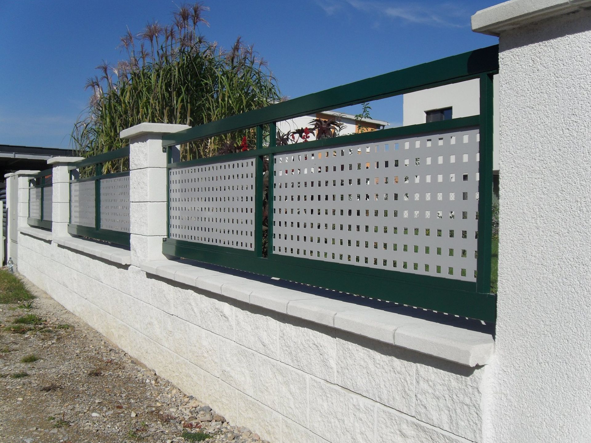 Ein grün-weißer Zaun mit Löchern darin