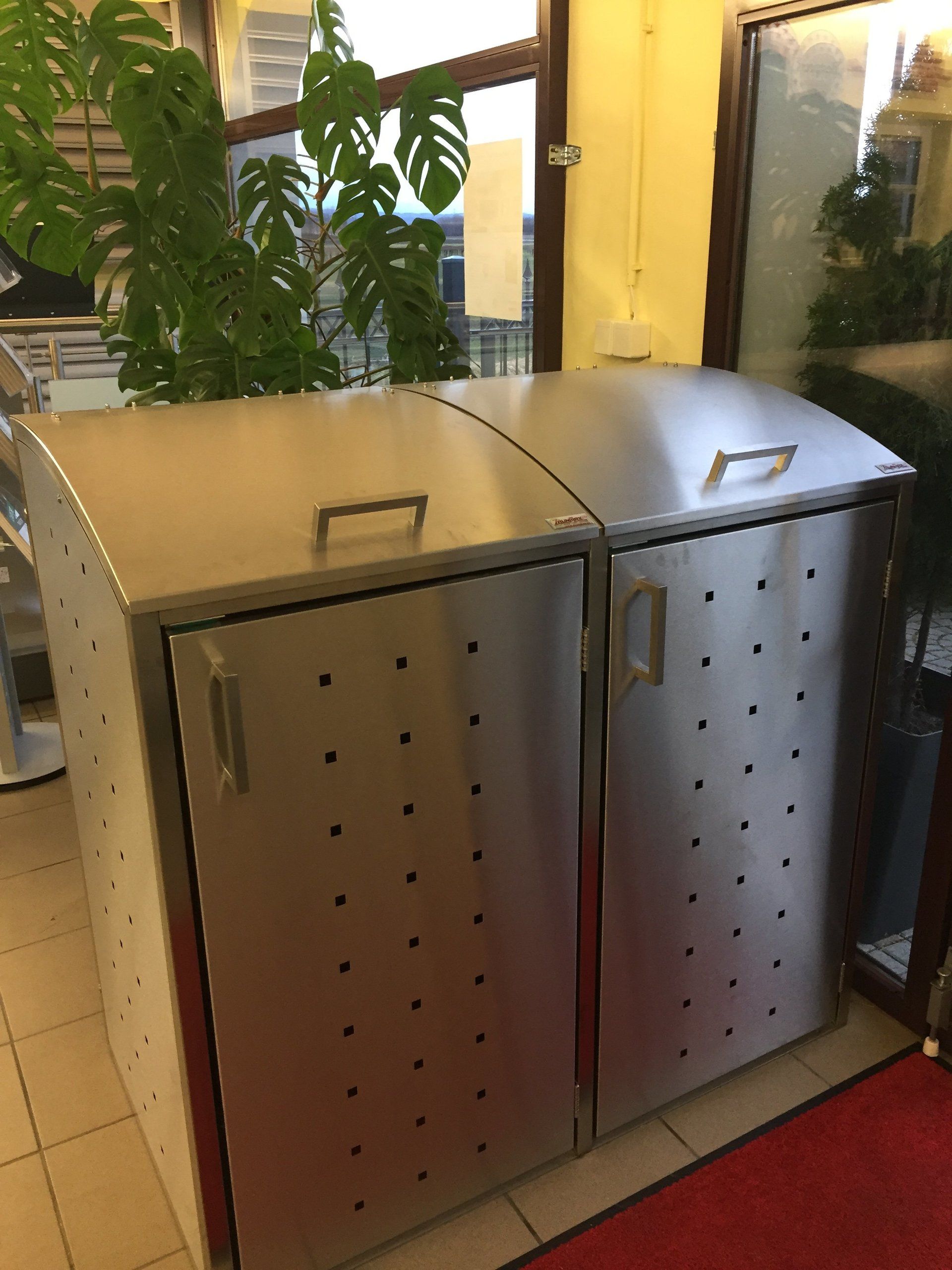 Zwei Mülleimer aus Edelstahl stehen nebeneinander in einem Raum