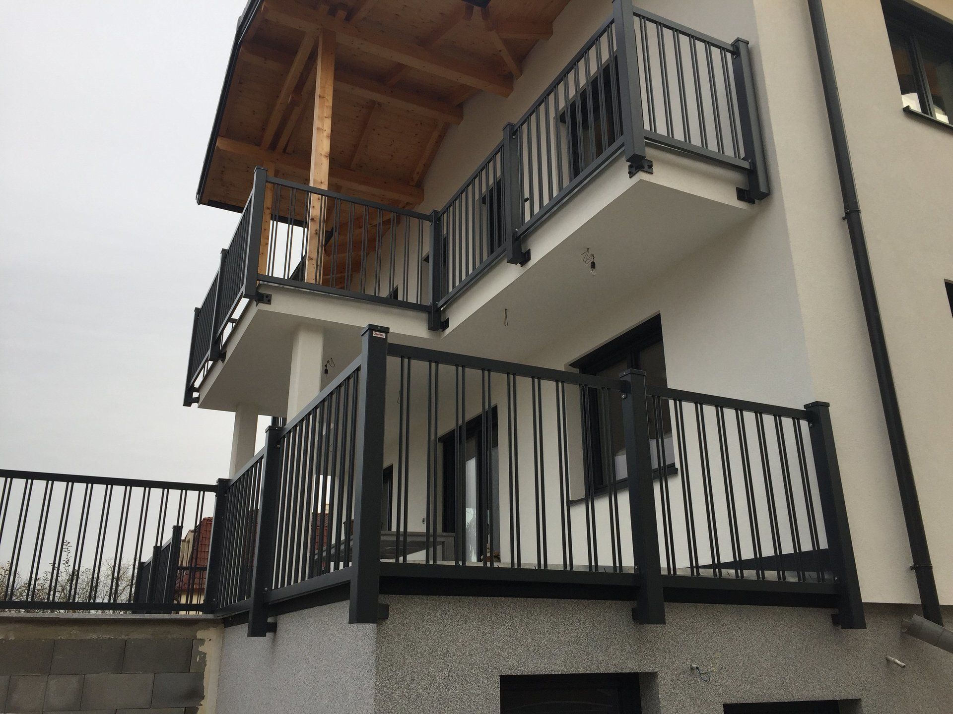 Ein Haus mit einem Balkon mit einem schwarzen Geländer