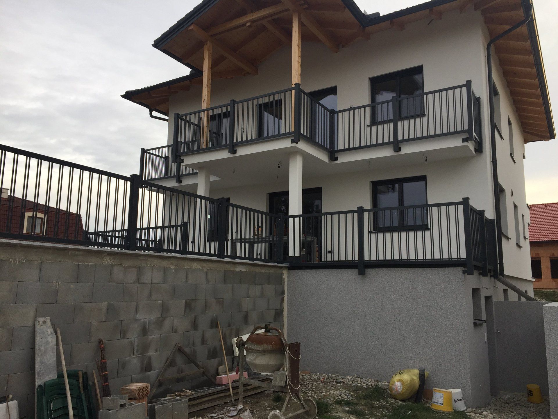 Ein großes weißes Haus mit einem Balkon und einem schwarzen Geländer