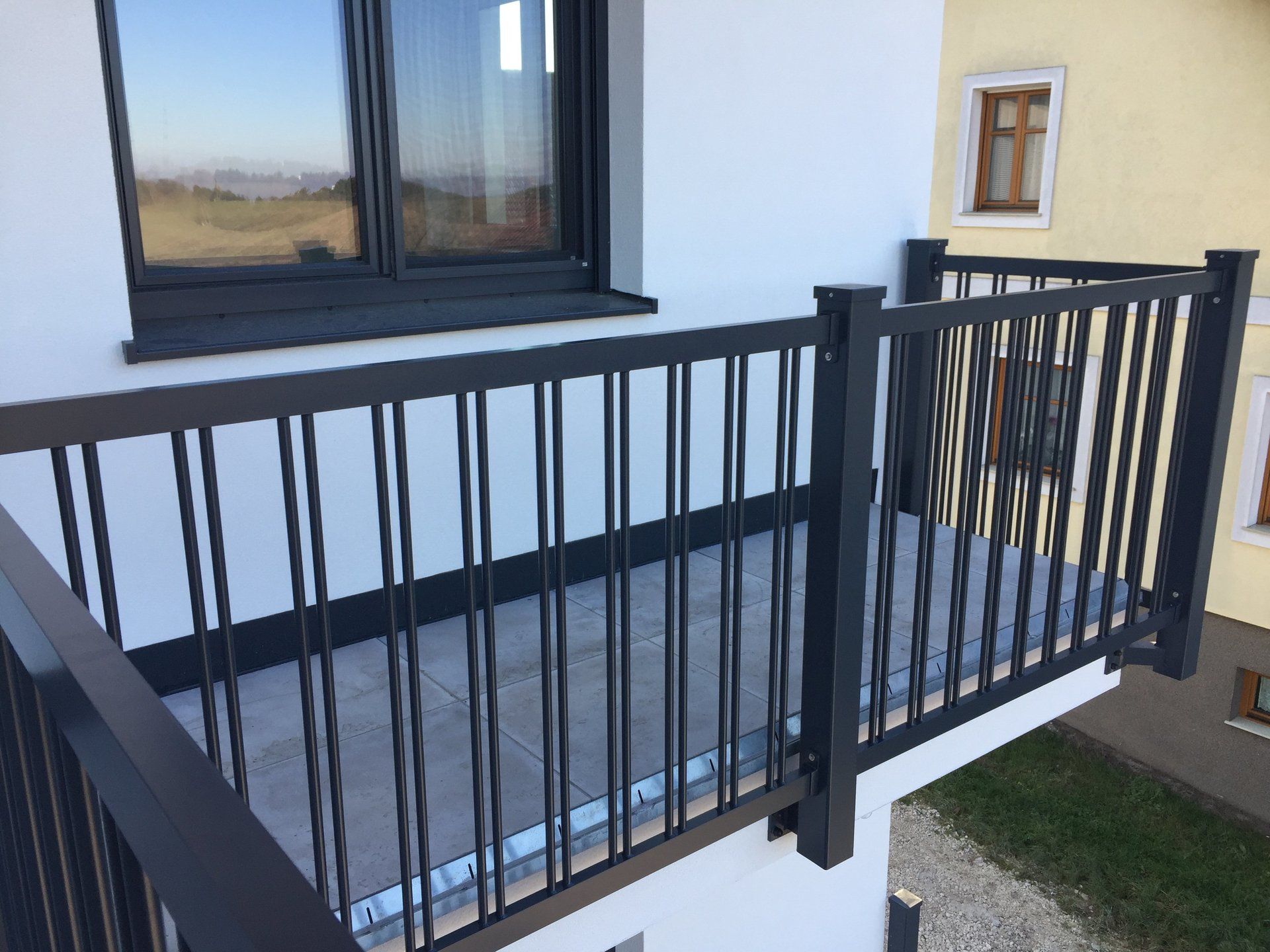 Ein Balkon mit einem schwarzen Geländer an der Seite eines Gebäudes