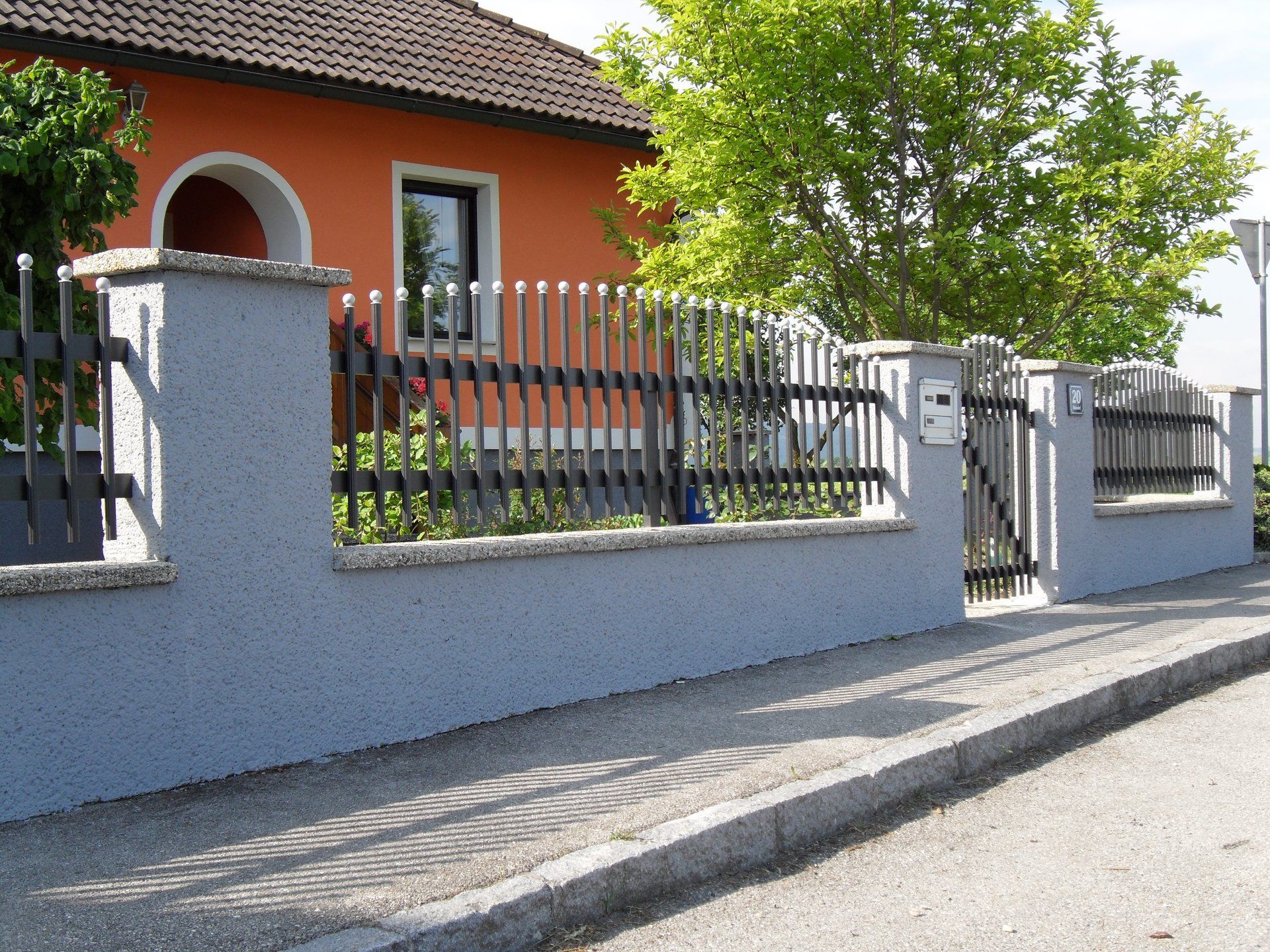 Ein orangefarbenes Haus mit einem Zaun darum