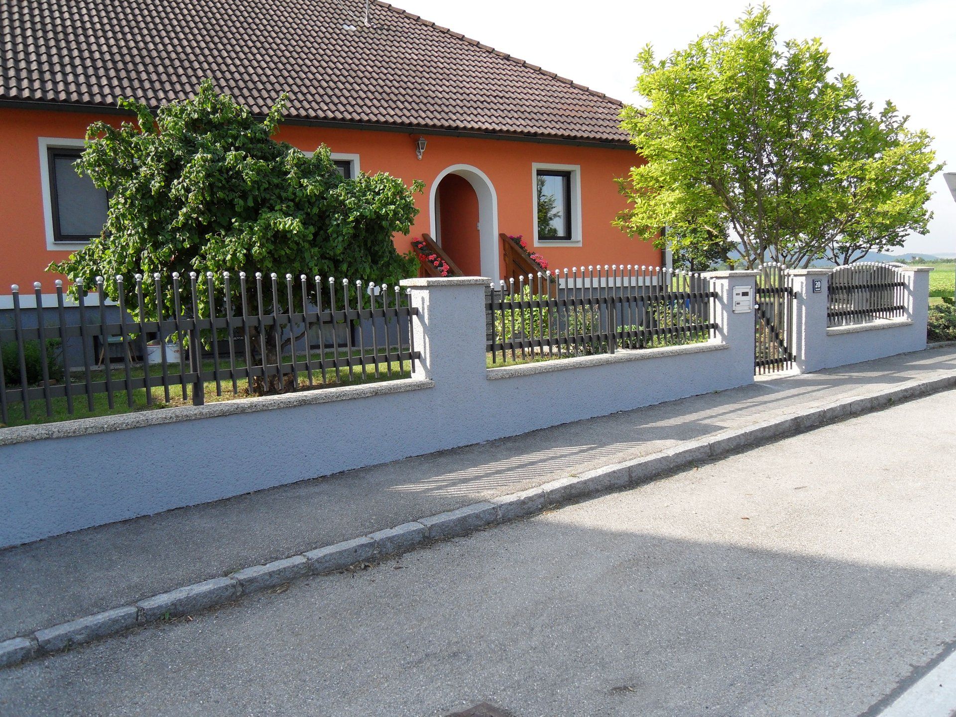 Ein orangefarbenes Haus mit einem Zaun darum