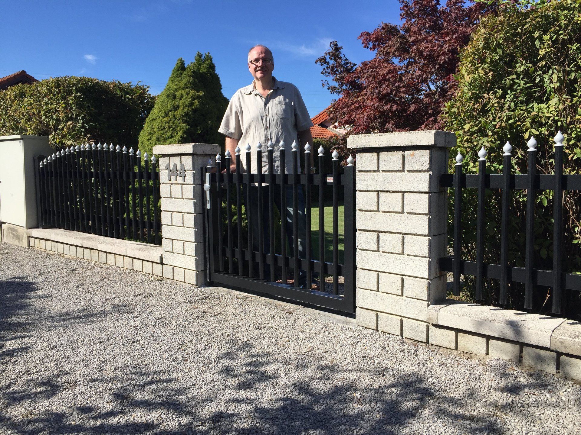 Ein Mann steht vor einem schwarzen Tor