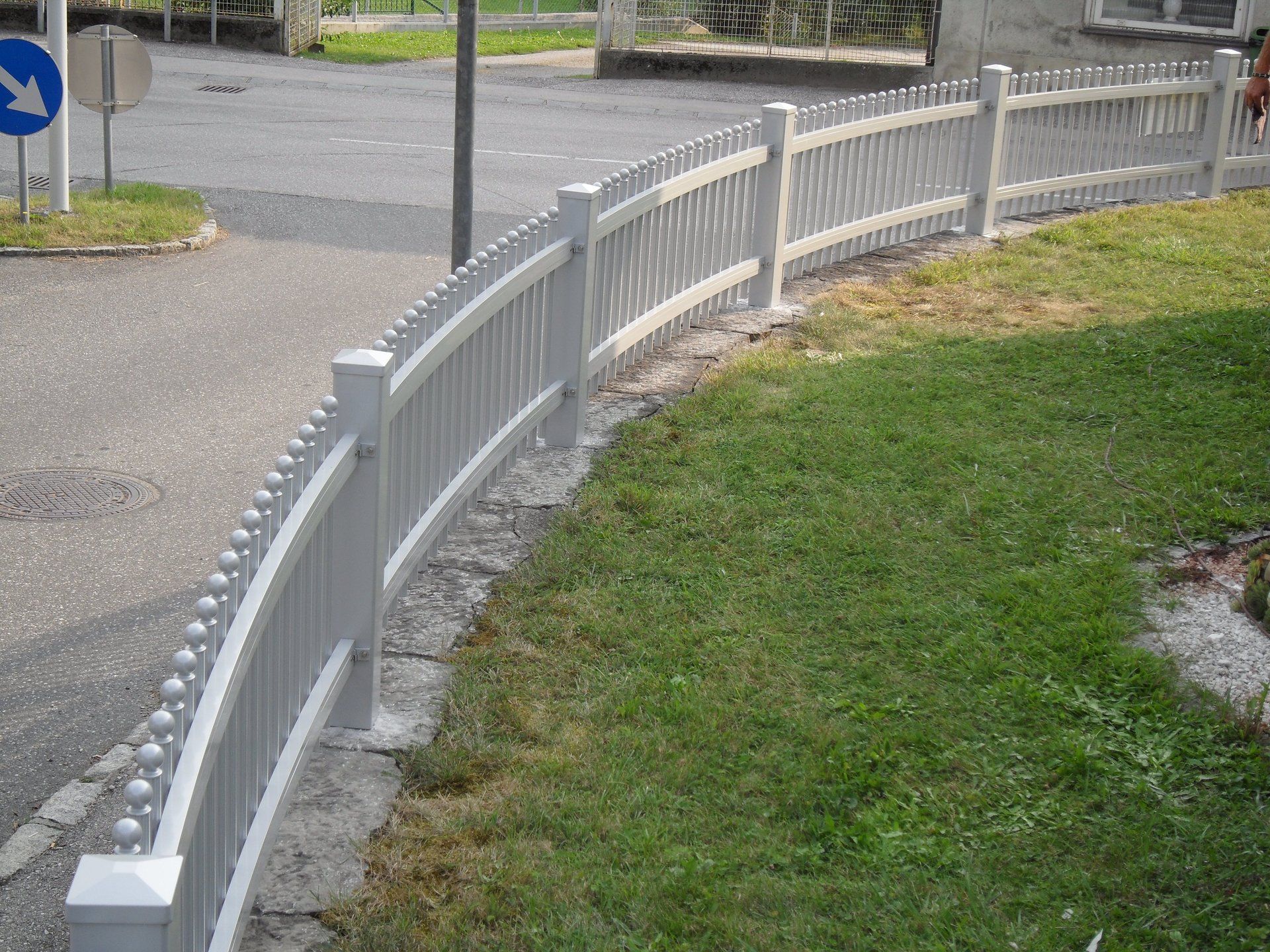 Ein weißer Zaun umgibt ein üppiges grünes Feld