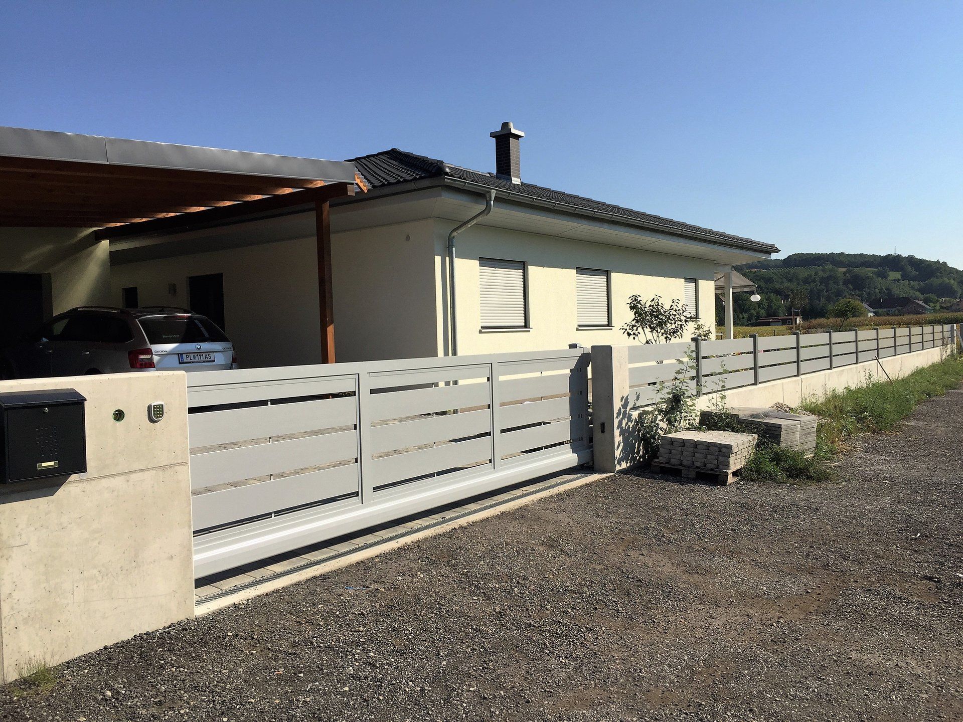 Ein Auto steht vor einem Haus mit Schiebetor