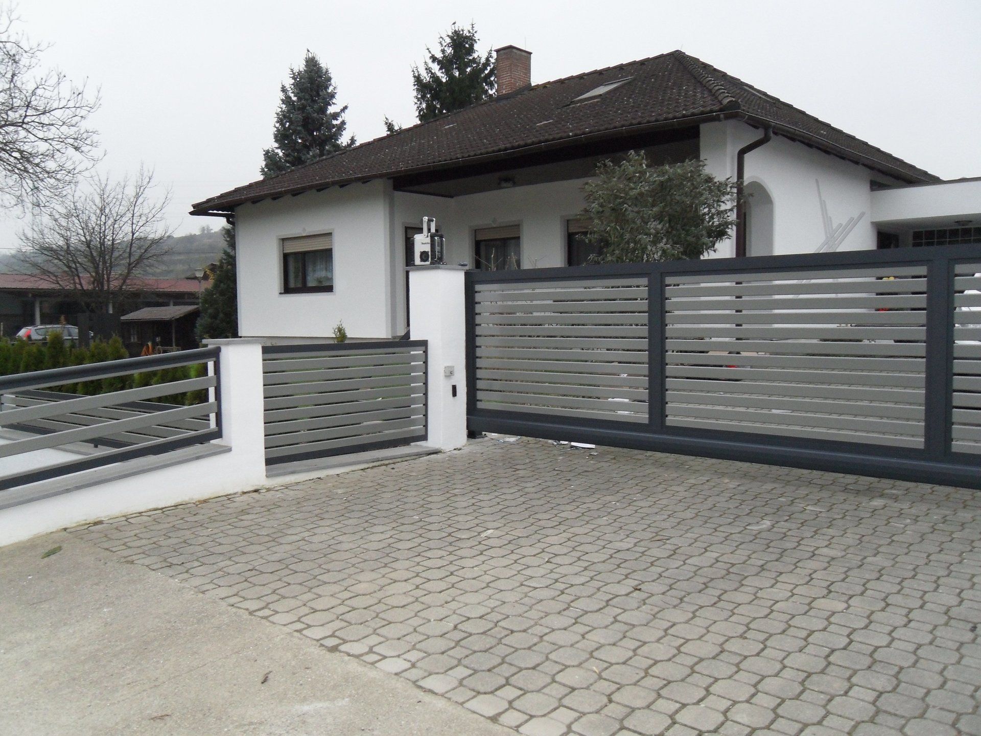 Ein Haus mit einem Schiebetor davor