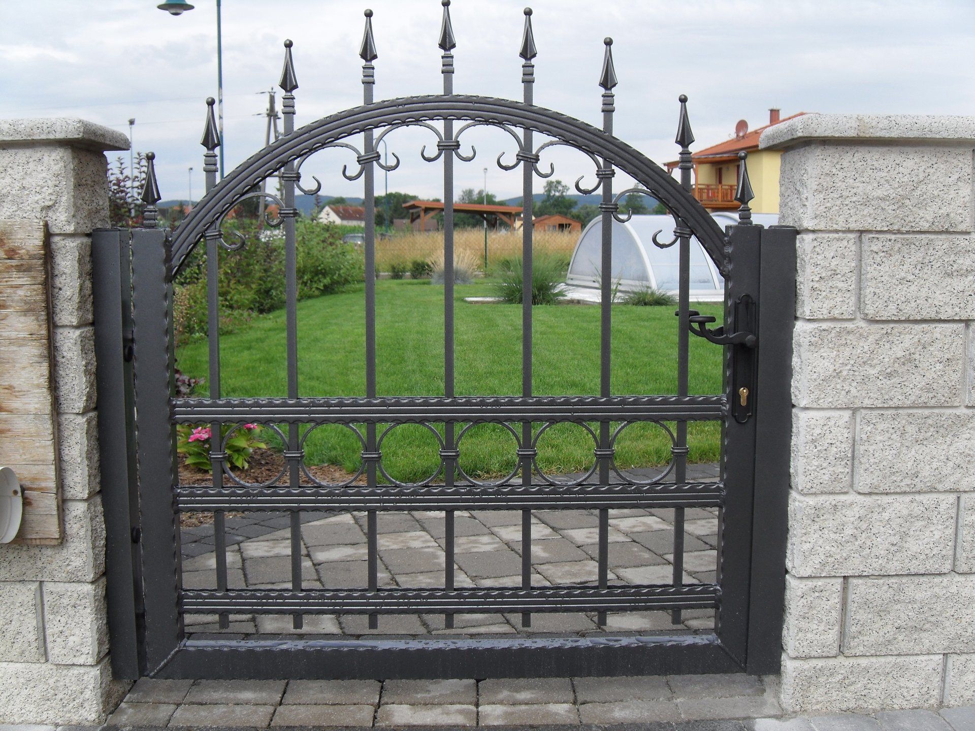 Ein schmiedeeisernes Tor mit einer Backsteinmauer dahinter