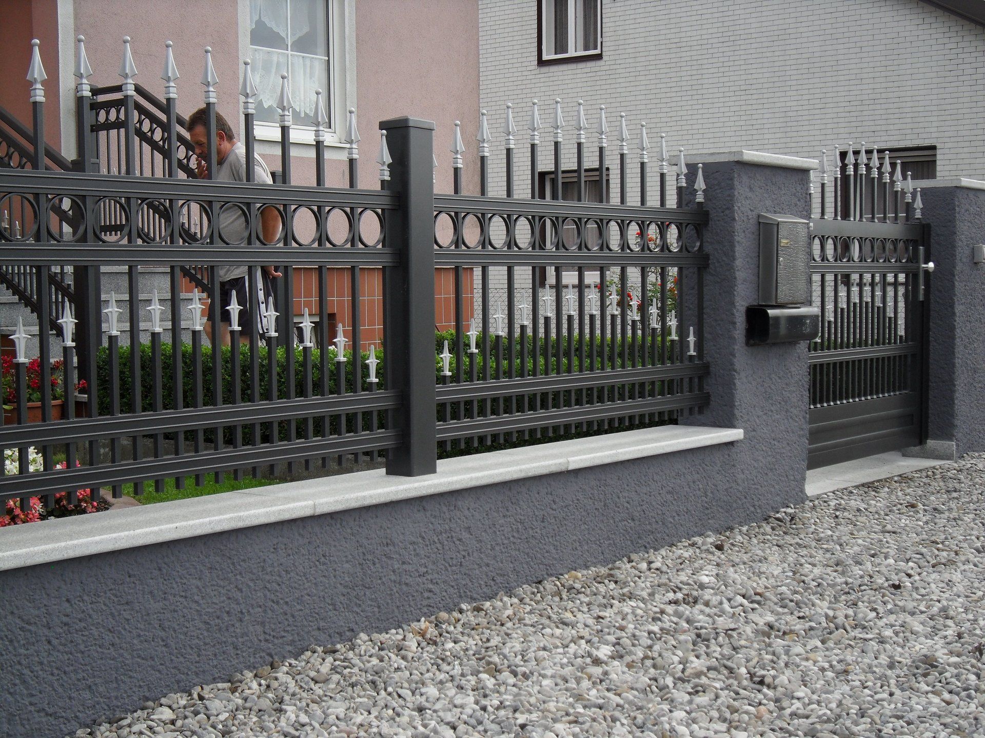 Ein Zaun mit einem Briefkasten vor einem Haus