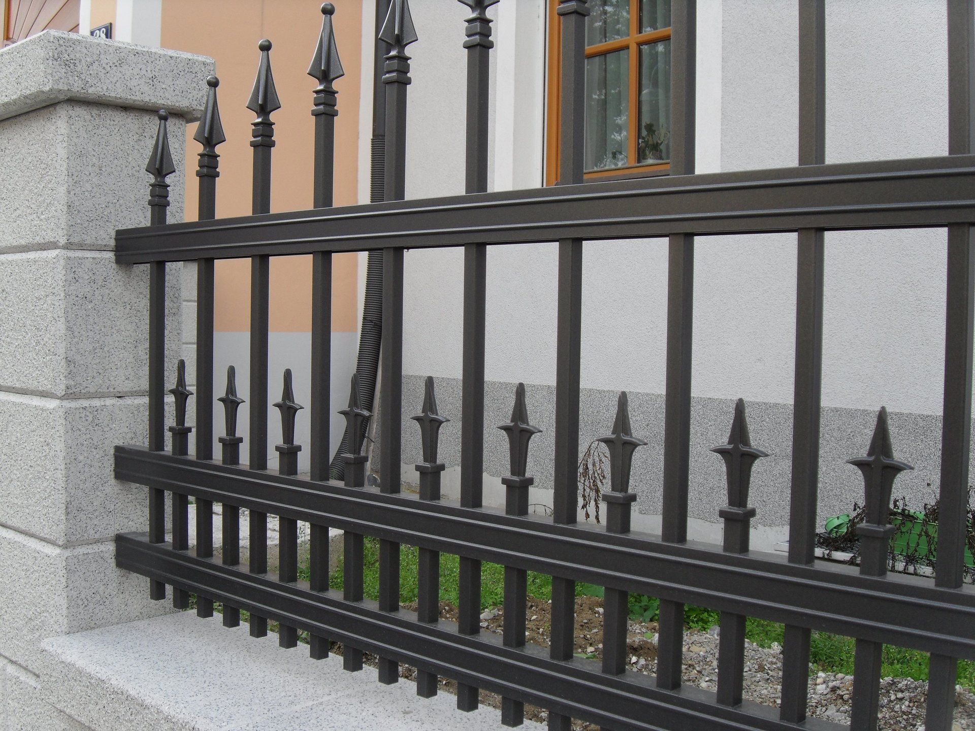 Ein schmiedeeiserner Zaun vor einem Gebäude