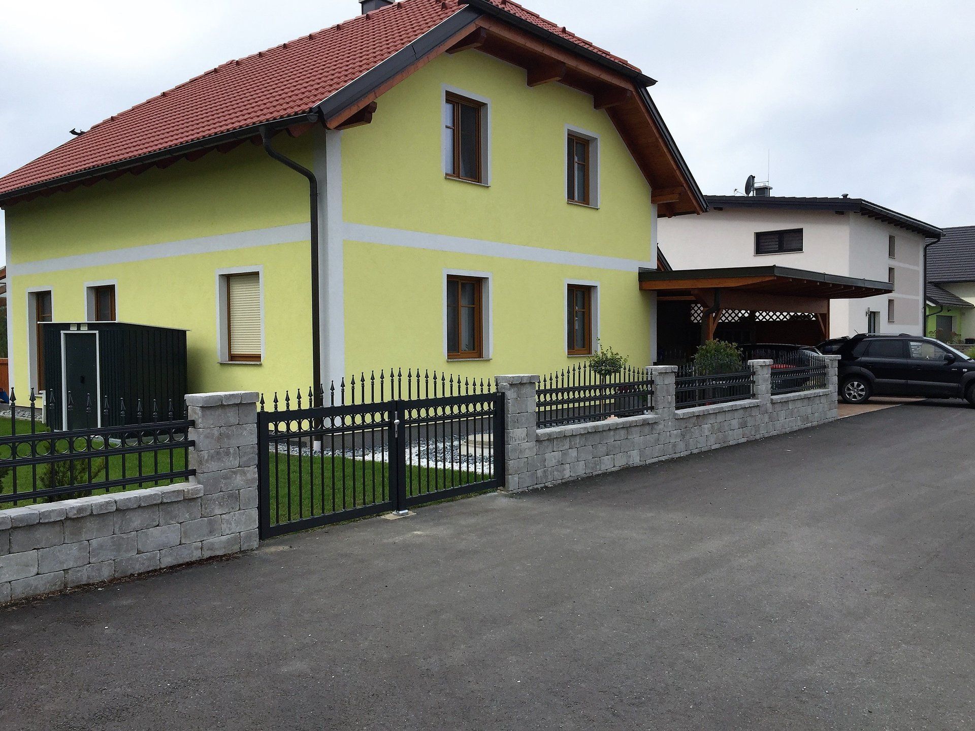 Ein gelbes Haus mit einem davor geparkten schwarzen Auto