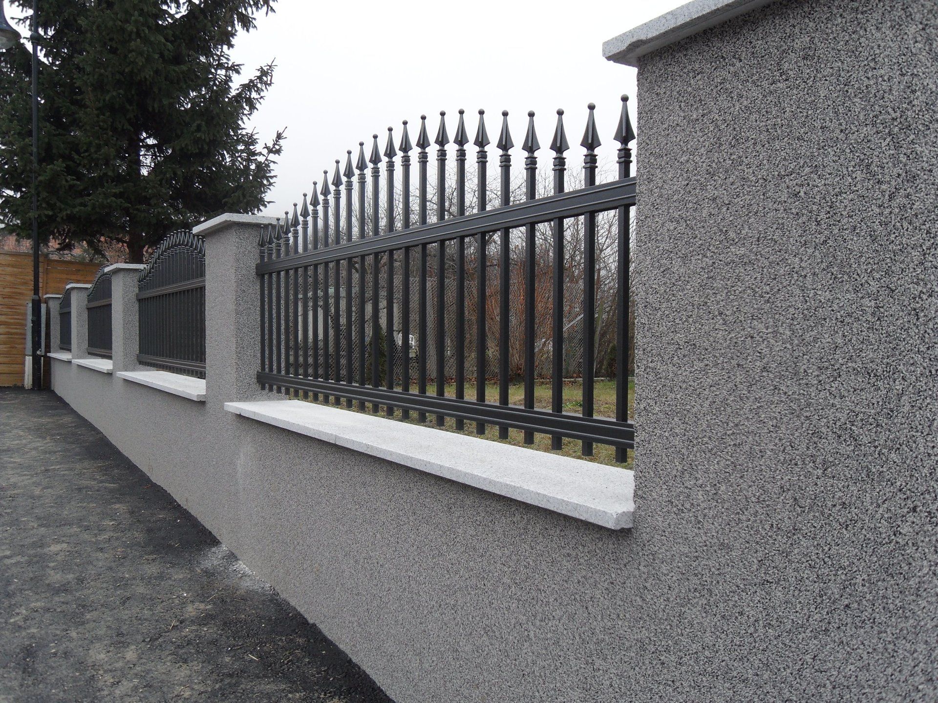 Eine Steinmauer, die von einem Metallzaun umgeben ist