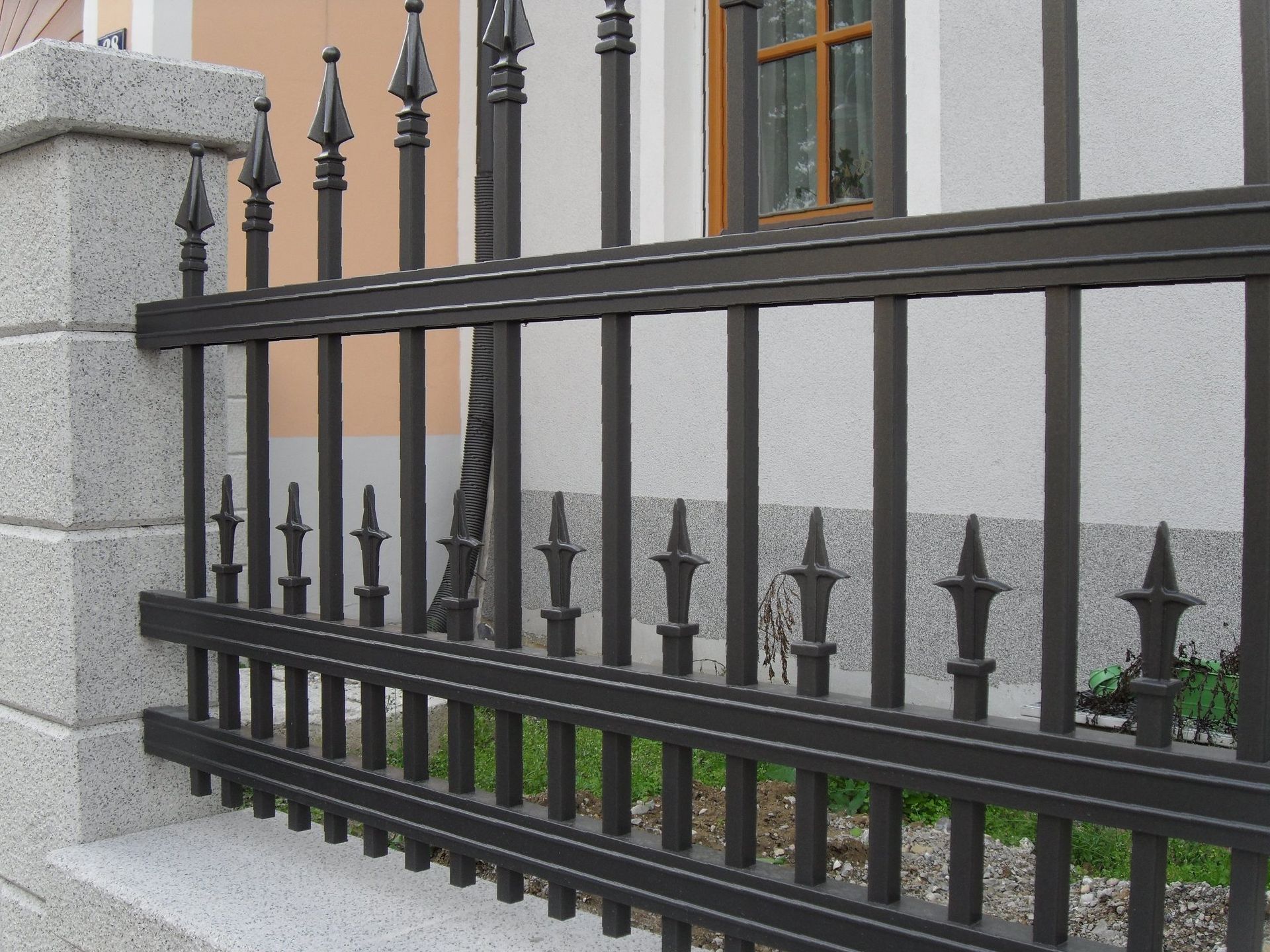 Ein schmiedeeiserner Zaun vor einem Gebäude